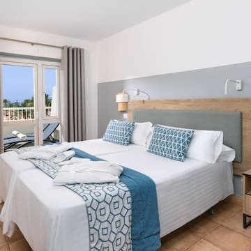 a bed with white and blue blankets and pillows