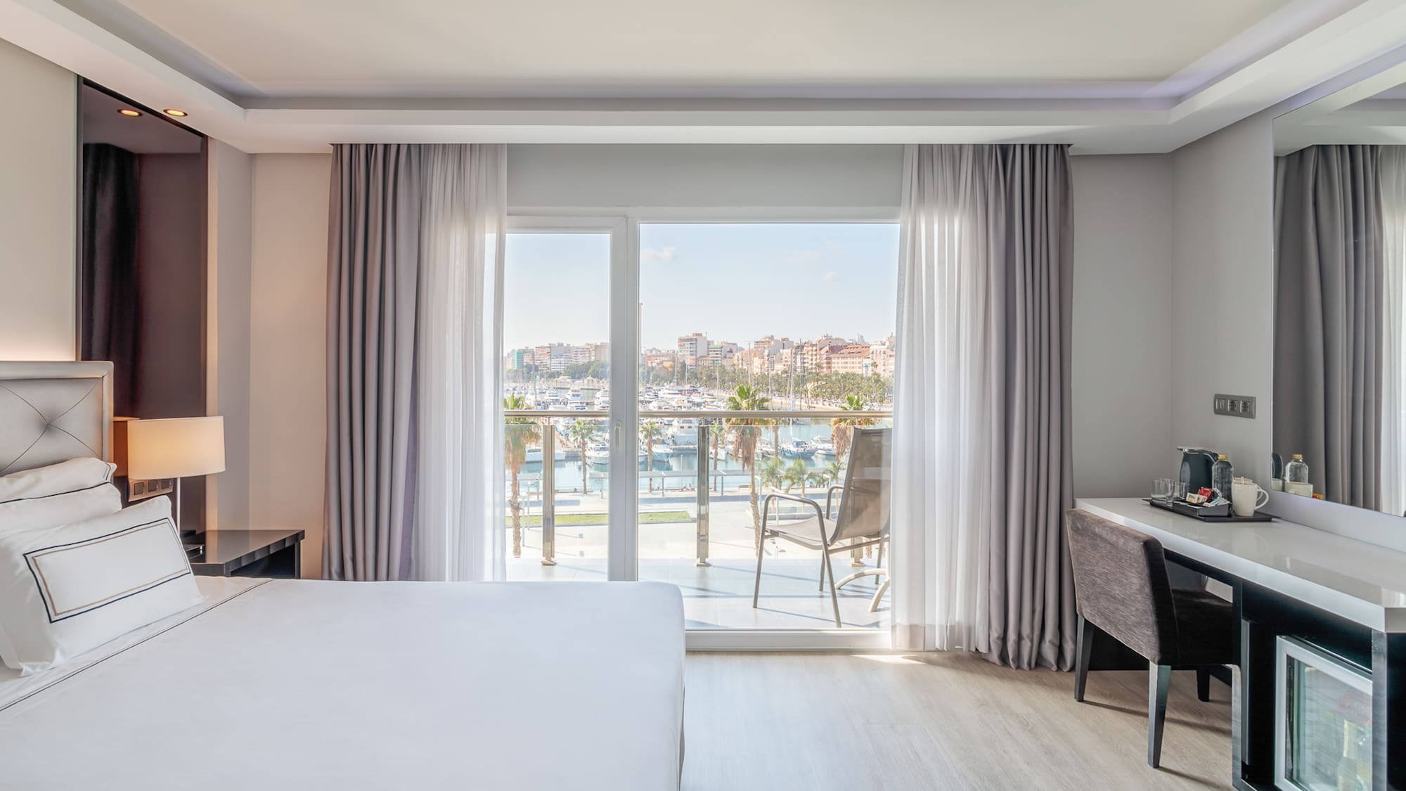 a room with a bed and a desk and a window