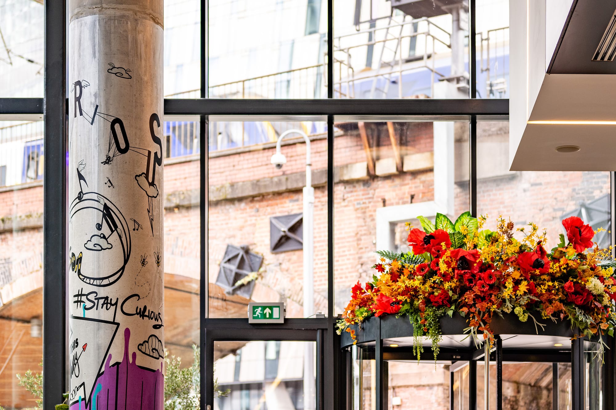 INSIDE by Melia Manchester lobby: graffiti pillar, floral revolving door.