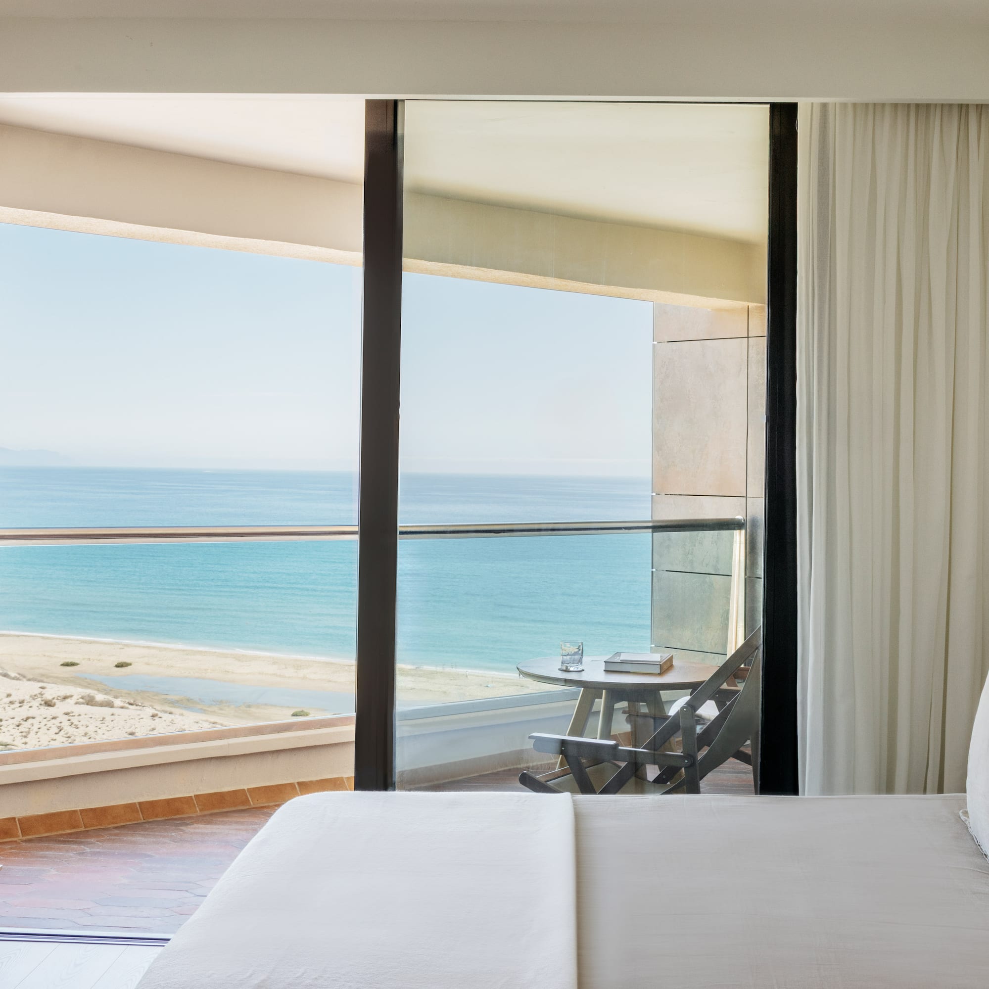 a bed with a view of the ocean from a balcony