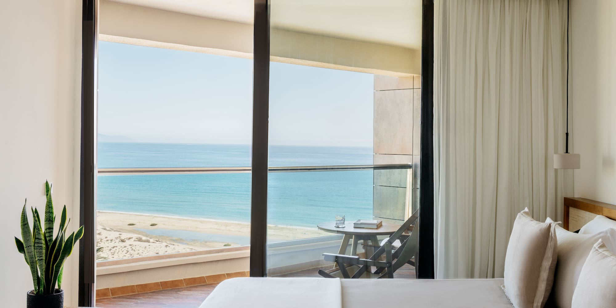 a bed with a view of the ocean from a balcony