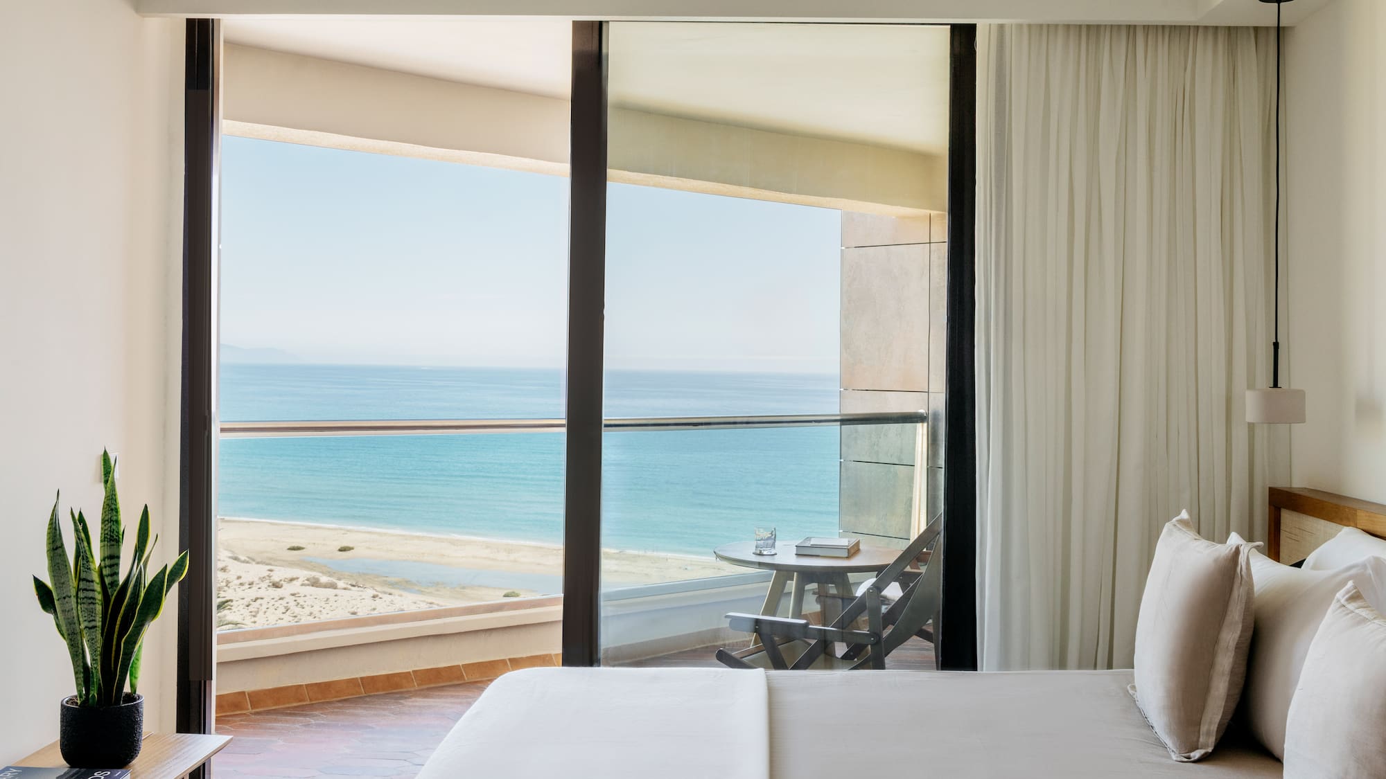 a bed with a view of the ocean from a balcony