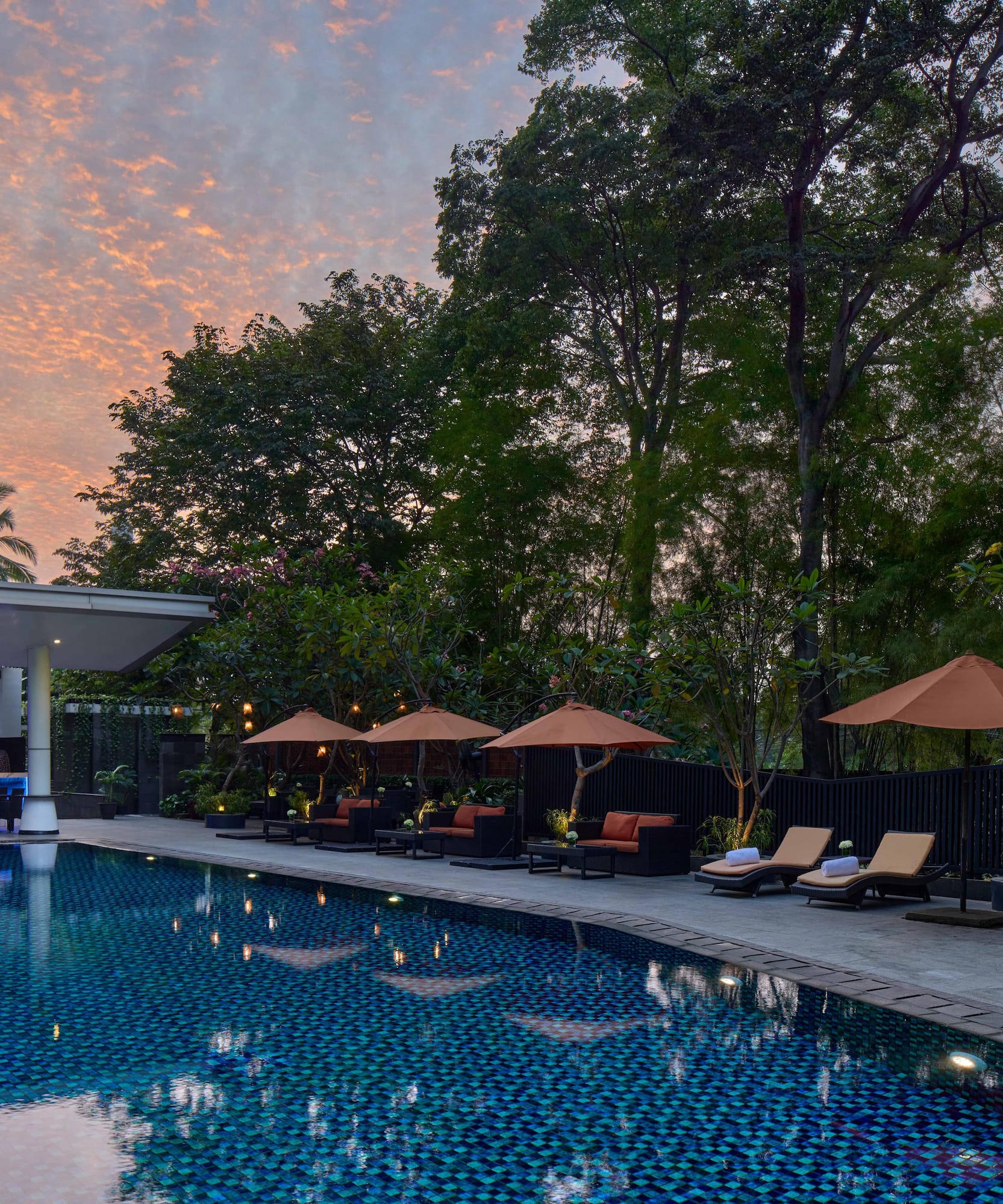 a pool with umbrellas and chairs in the foreground