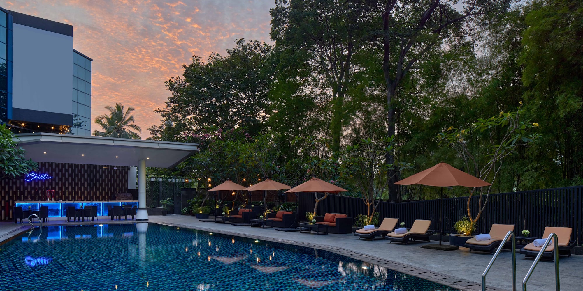 a pool with umbrellas and chairs in the foreground