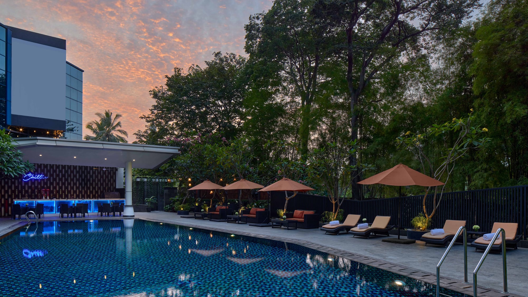 a pool with umbrellas and chairs in the foreground