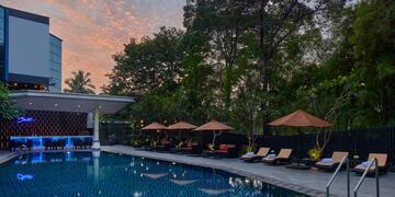 a pool with umbrellas and chairs in the foreground