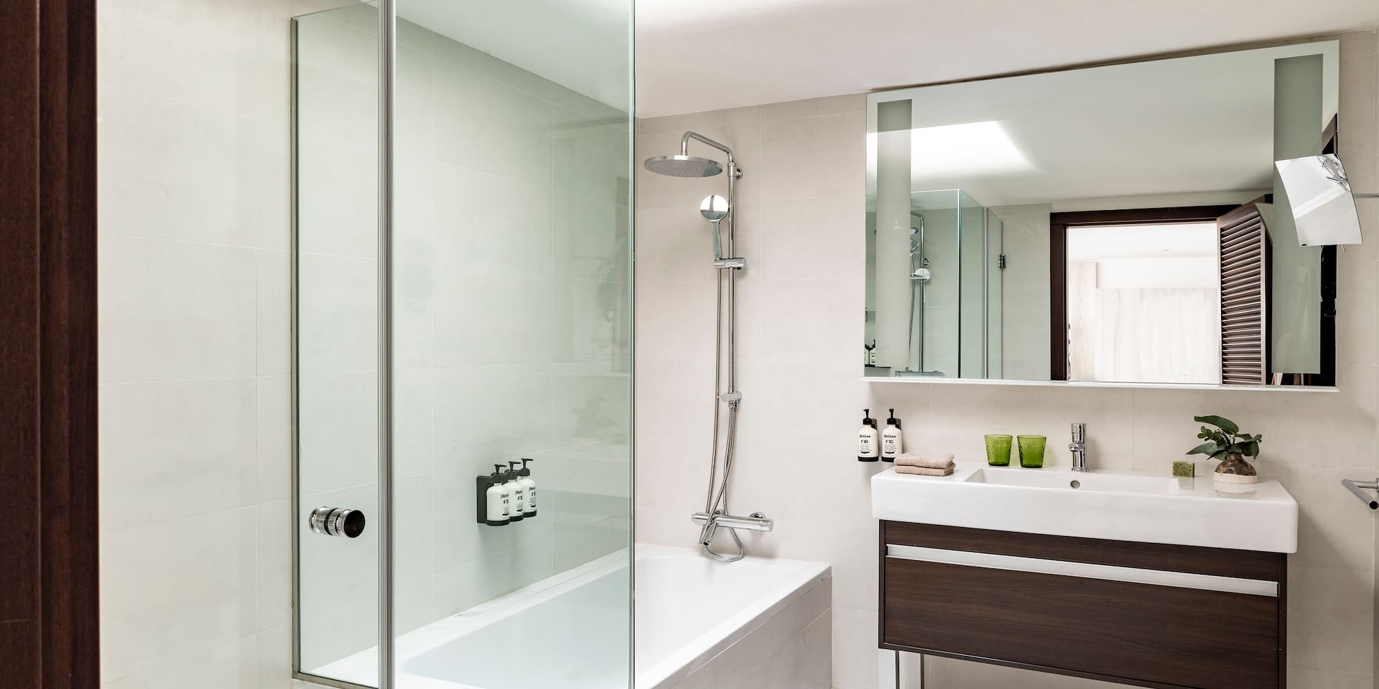 a bathroom with a glass shower and tub