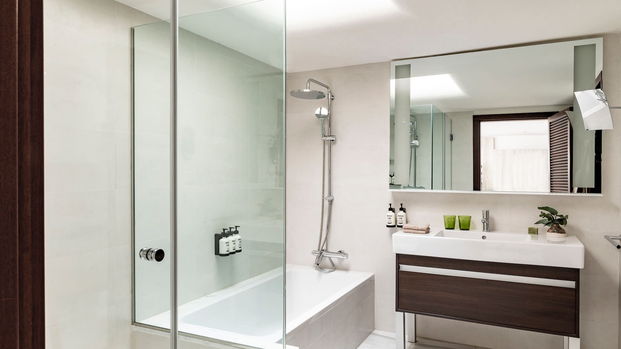 a bathroom with a glass shower and tub
