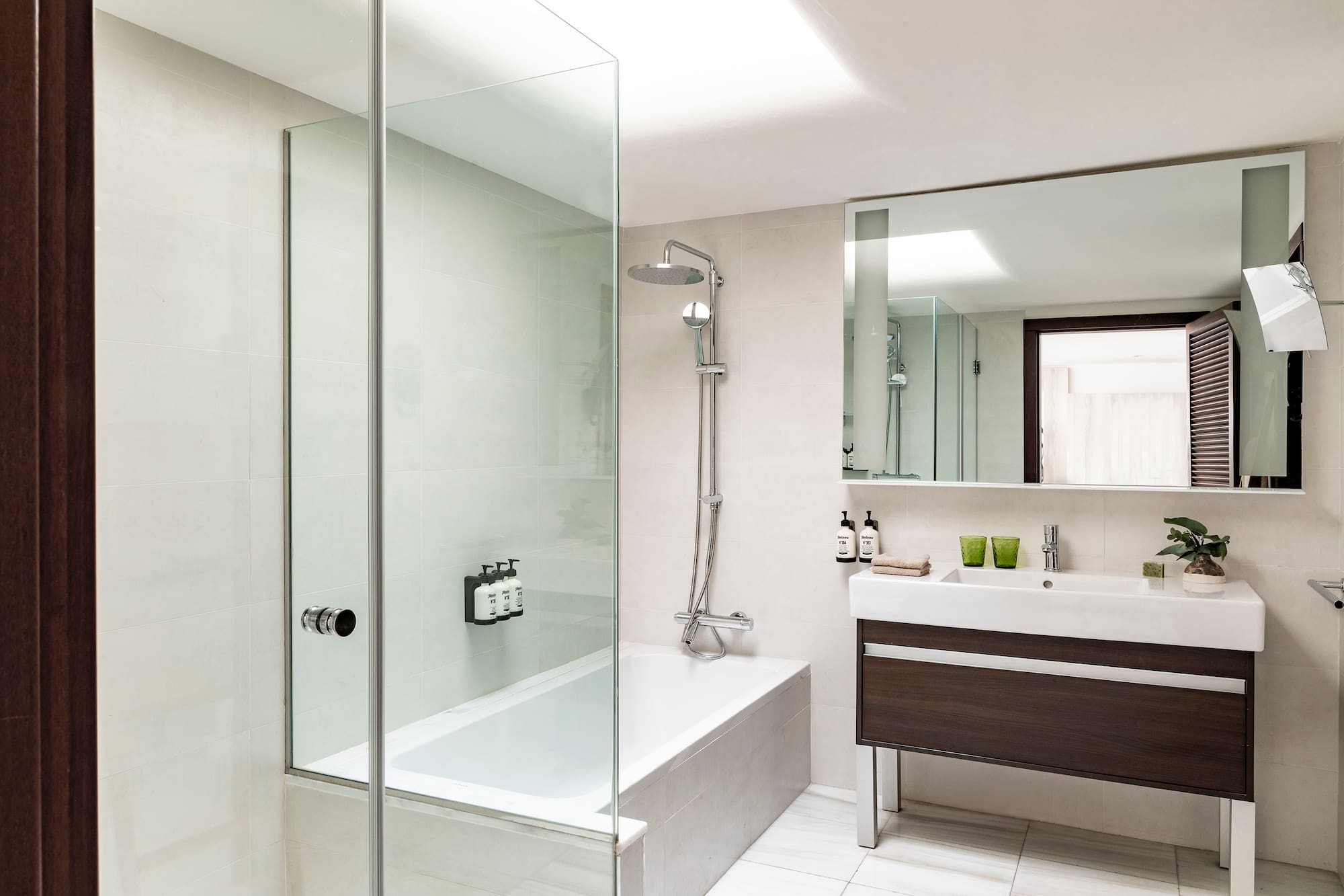 a bathroom with a glass shower and tub
