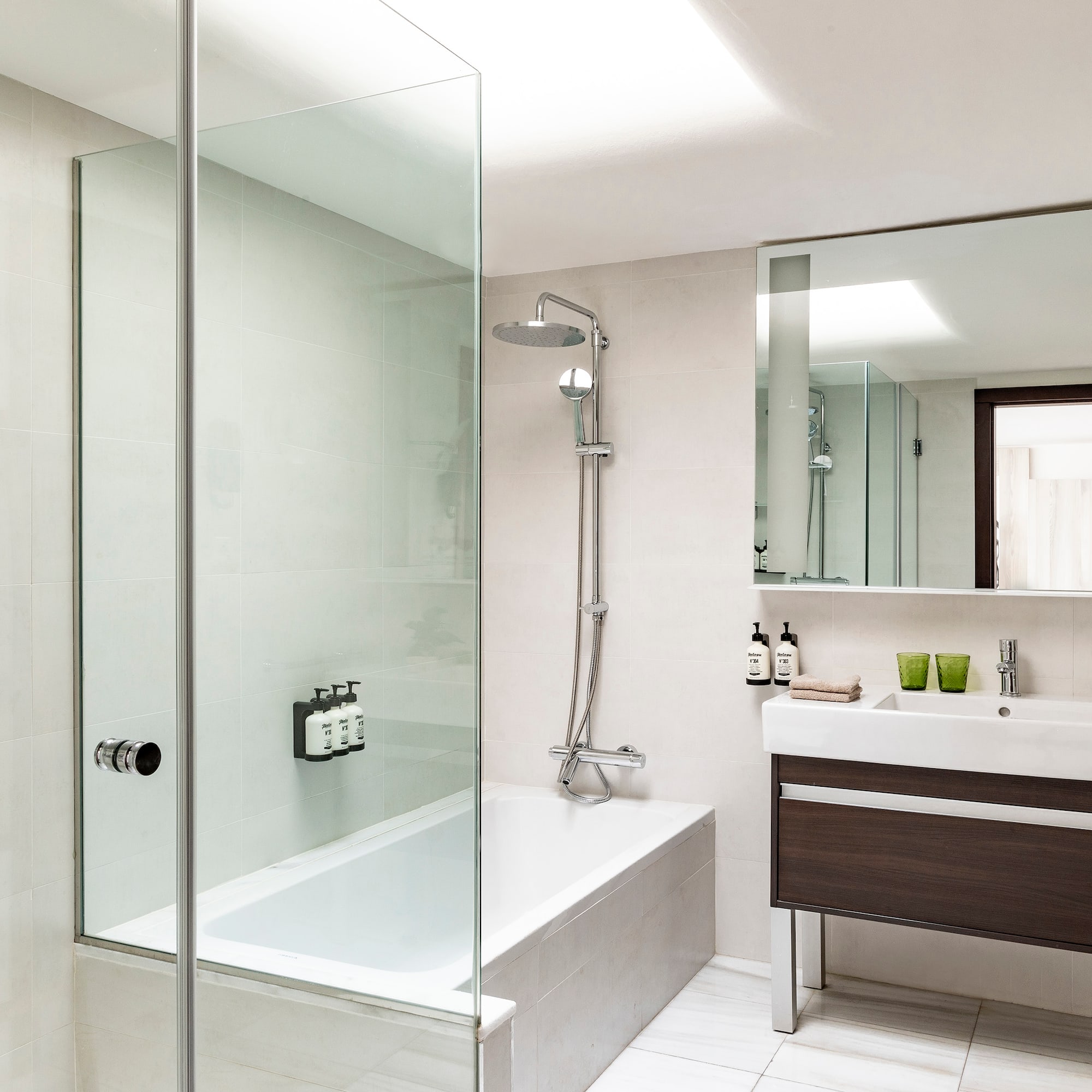 a bathroom with a glass shower and tub