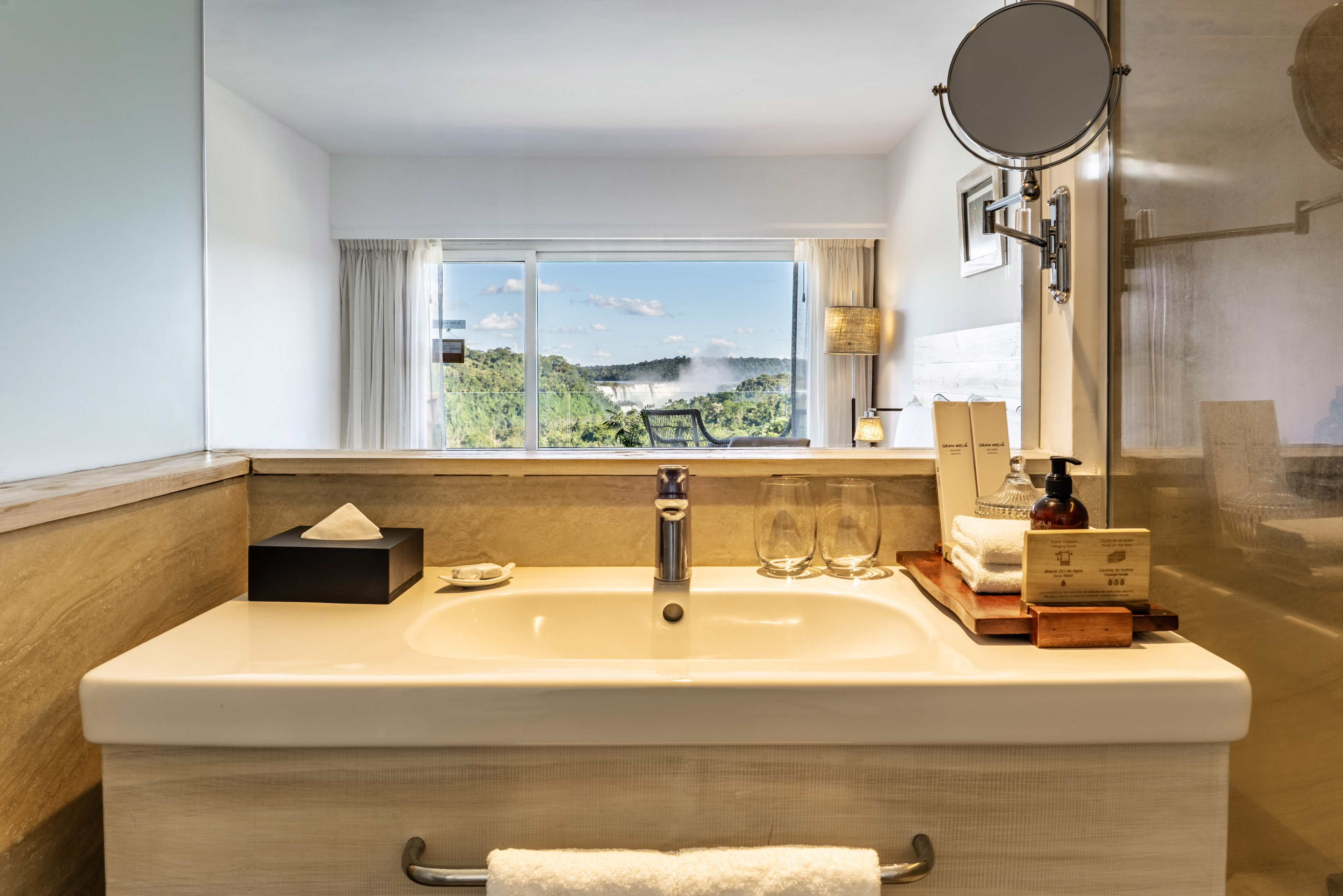 Bathroom vanity with sink, toiletries, and Iguazu Falls view.