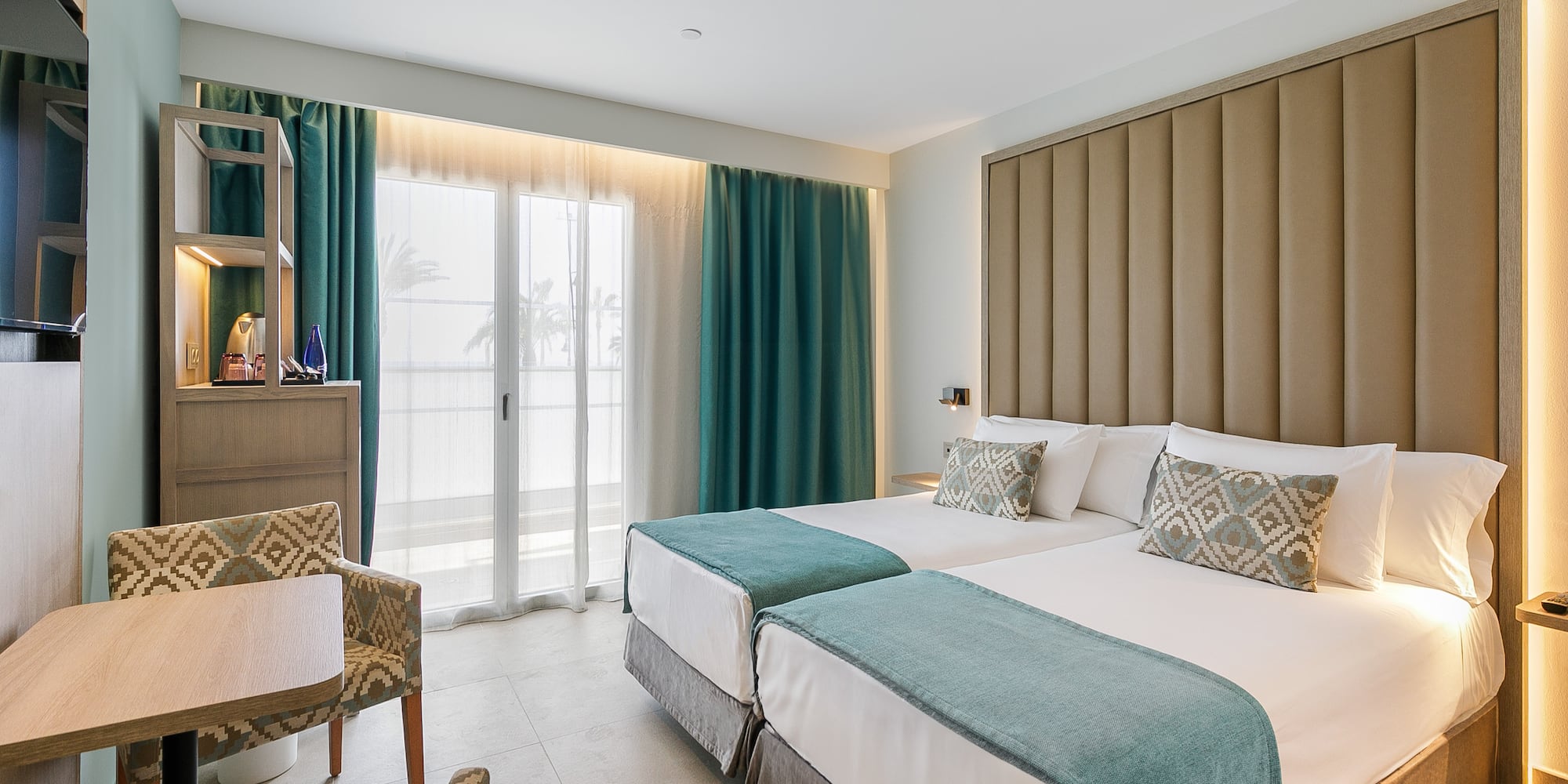 a room with two beds and a chair