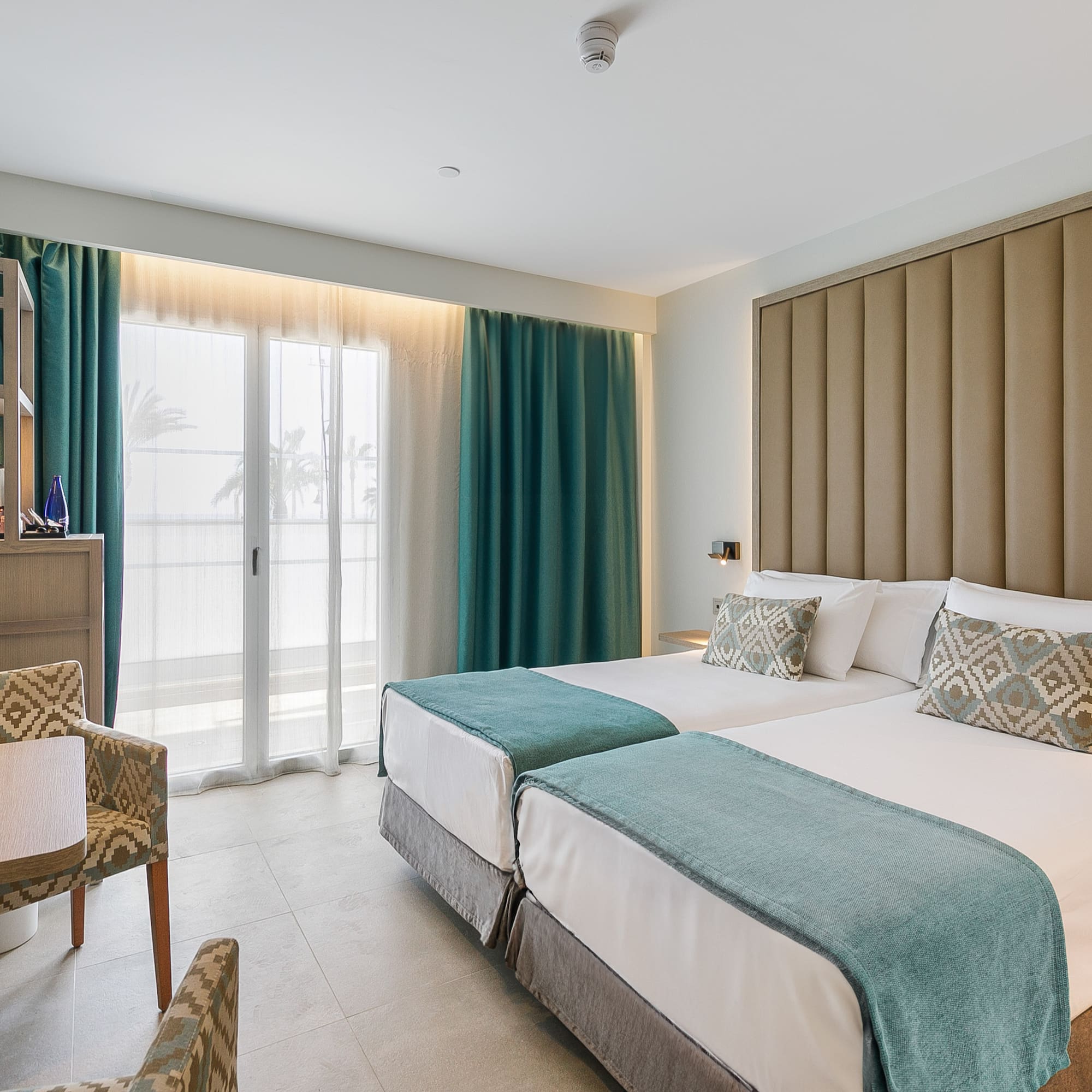 a room with two beds and a chair