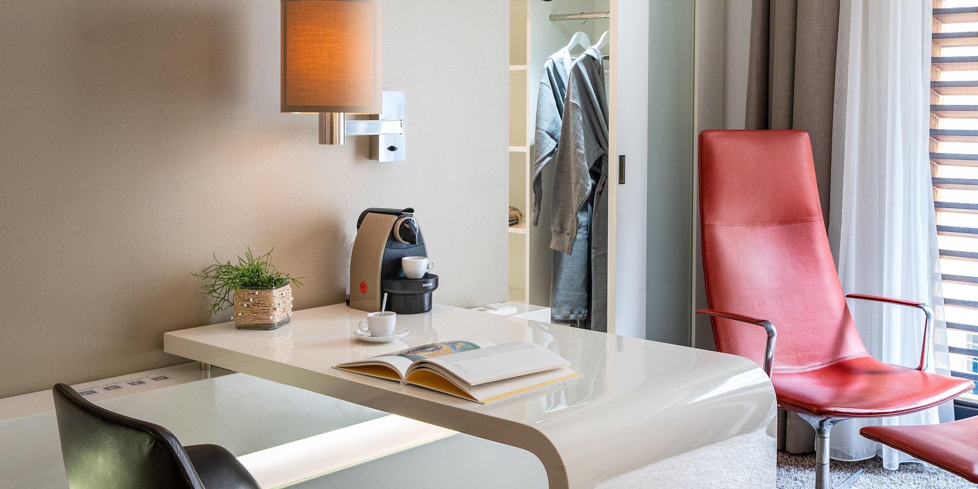 a desk with a coffee cup and a book in front of a closet