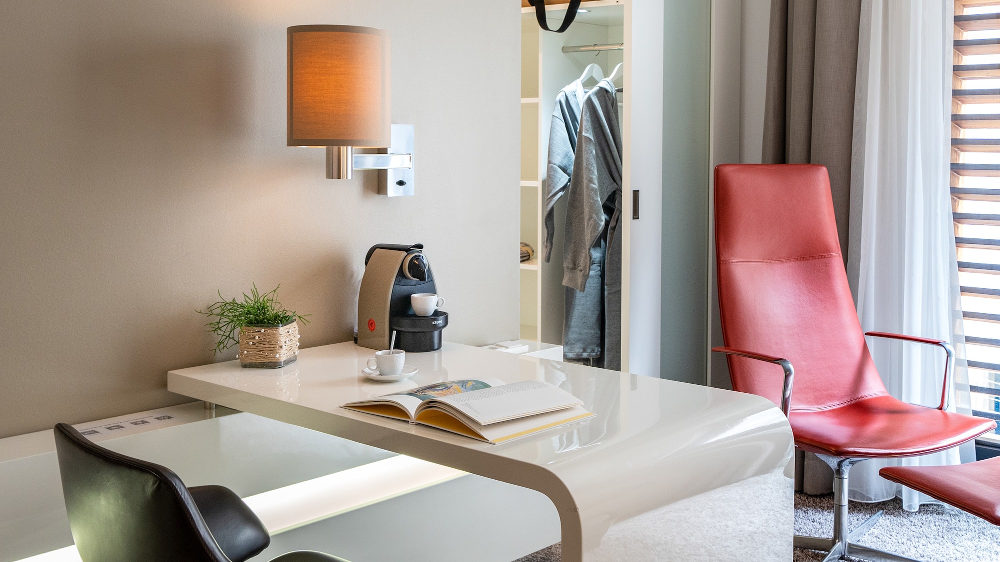 a desk with a coffee cup and a book in front of a closet