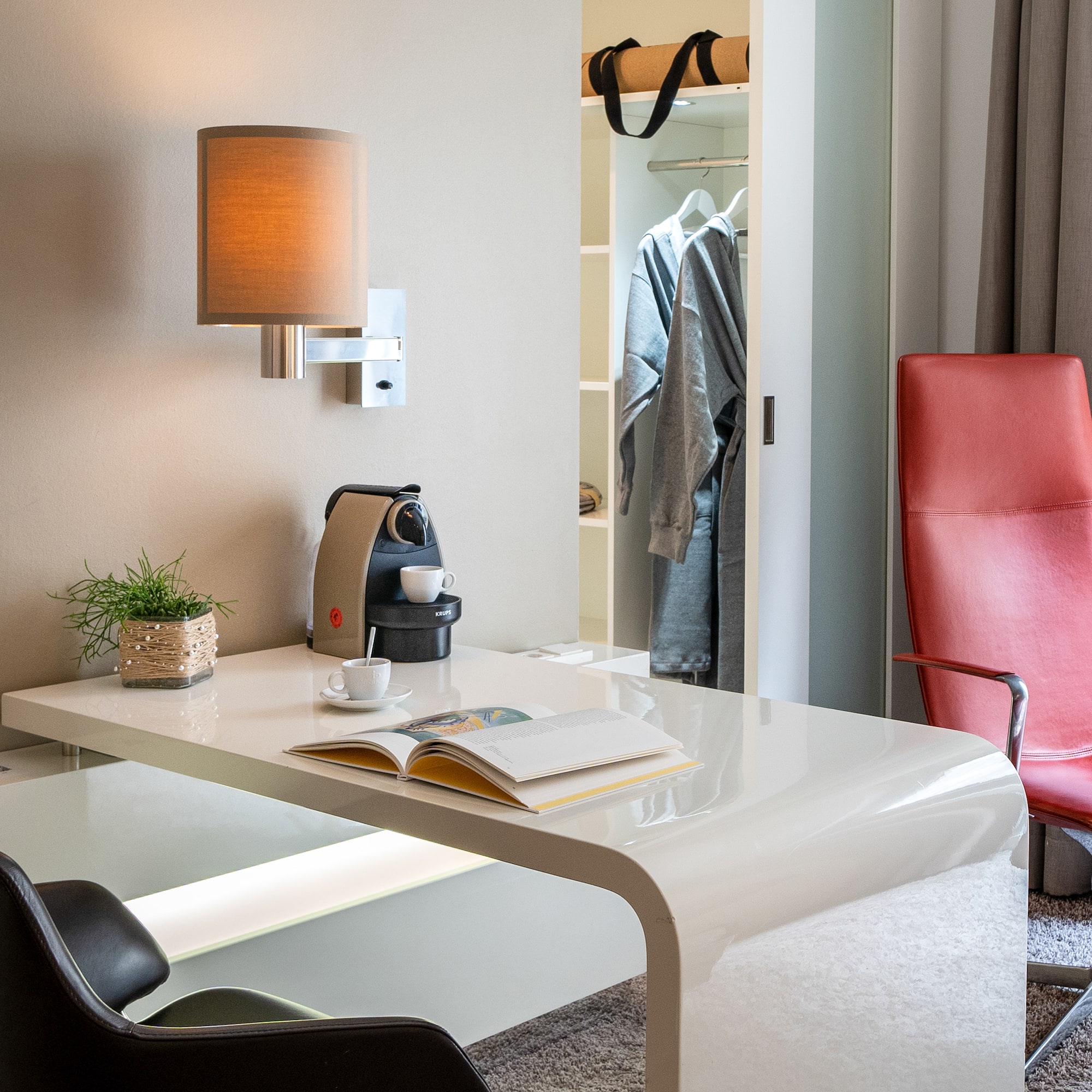 a desk with a coffee cup and a book in front of a closet