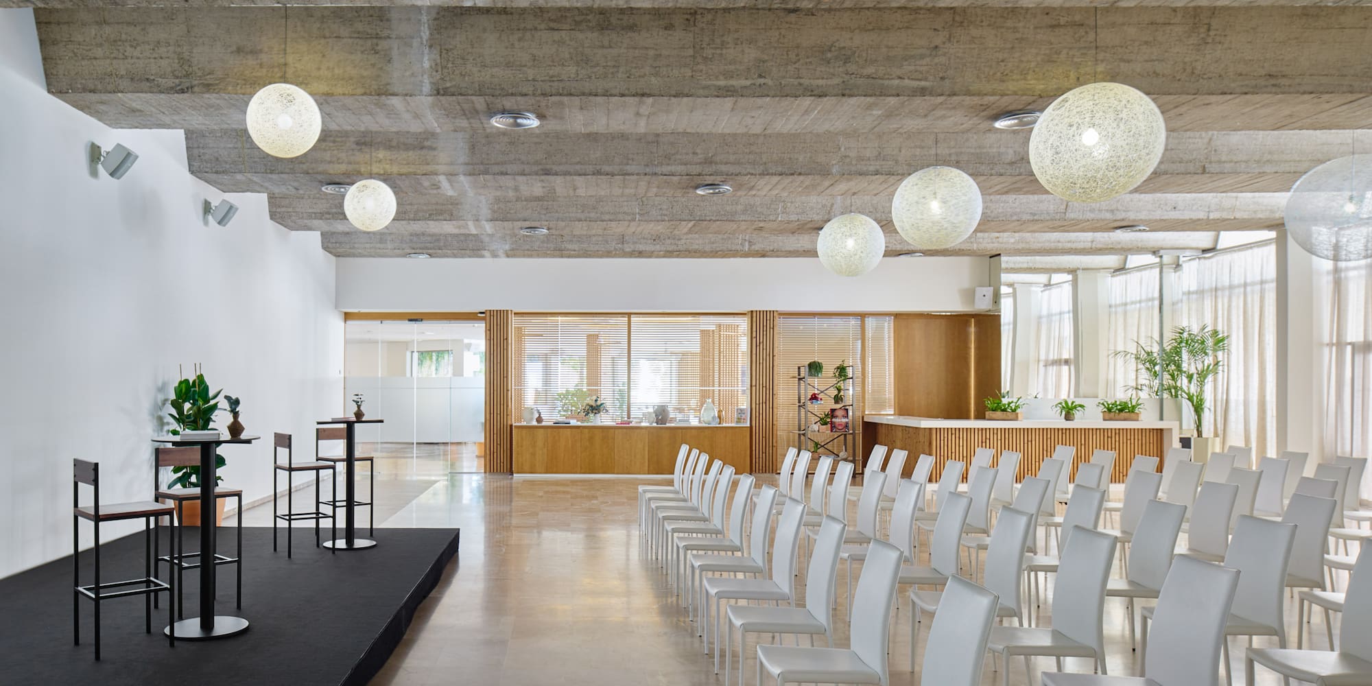 a room with white chairs and a stage