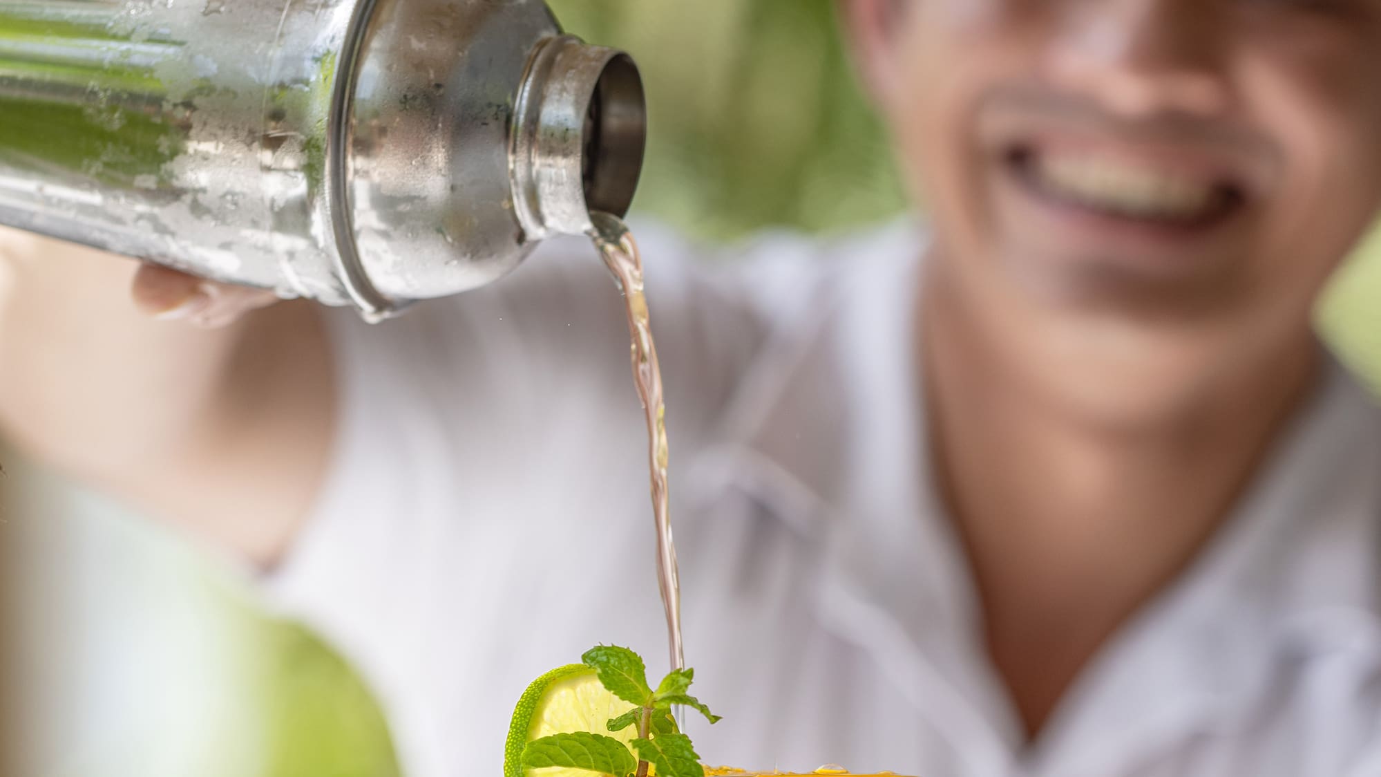 a man pouring a drink into a glass