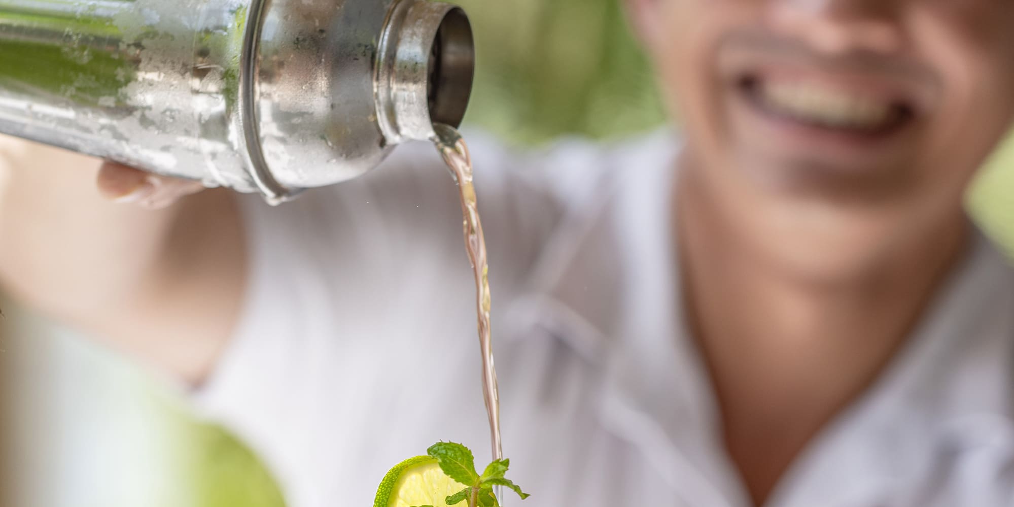 a man pouring a drink into a glass