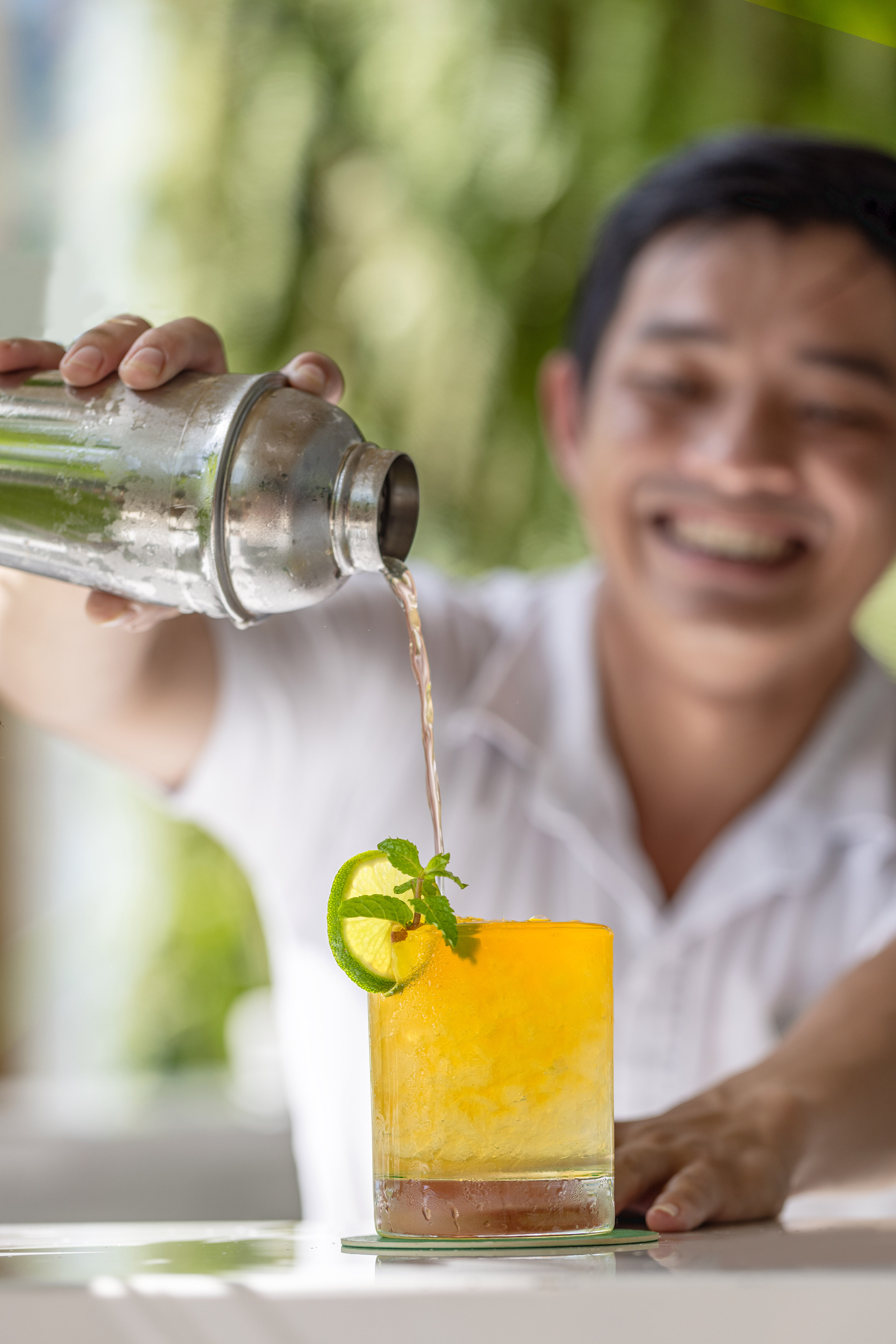 a man pouring a drink into a glass