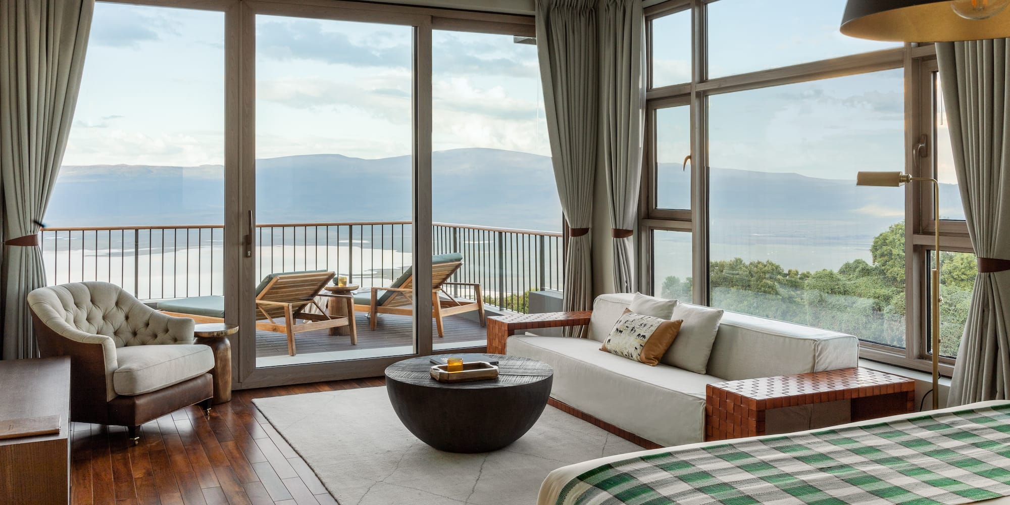 a room with a view of the ocean and a couch and a table