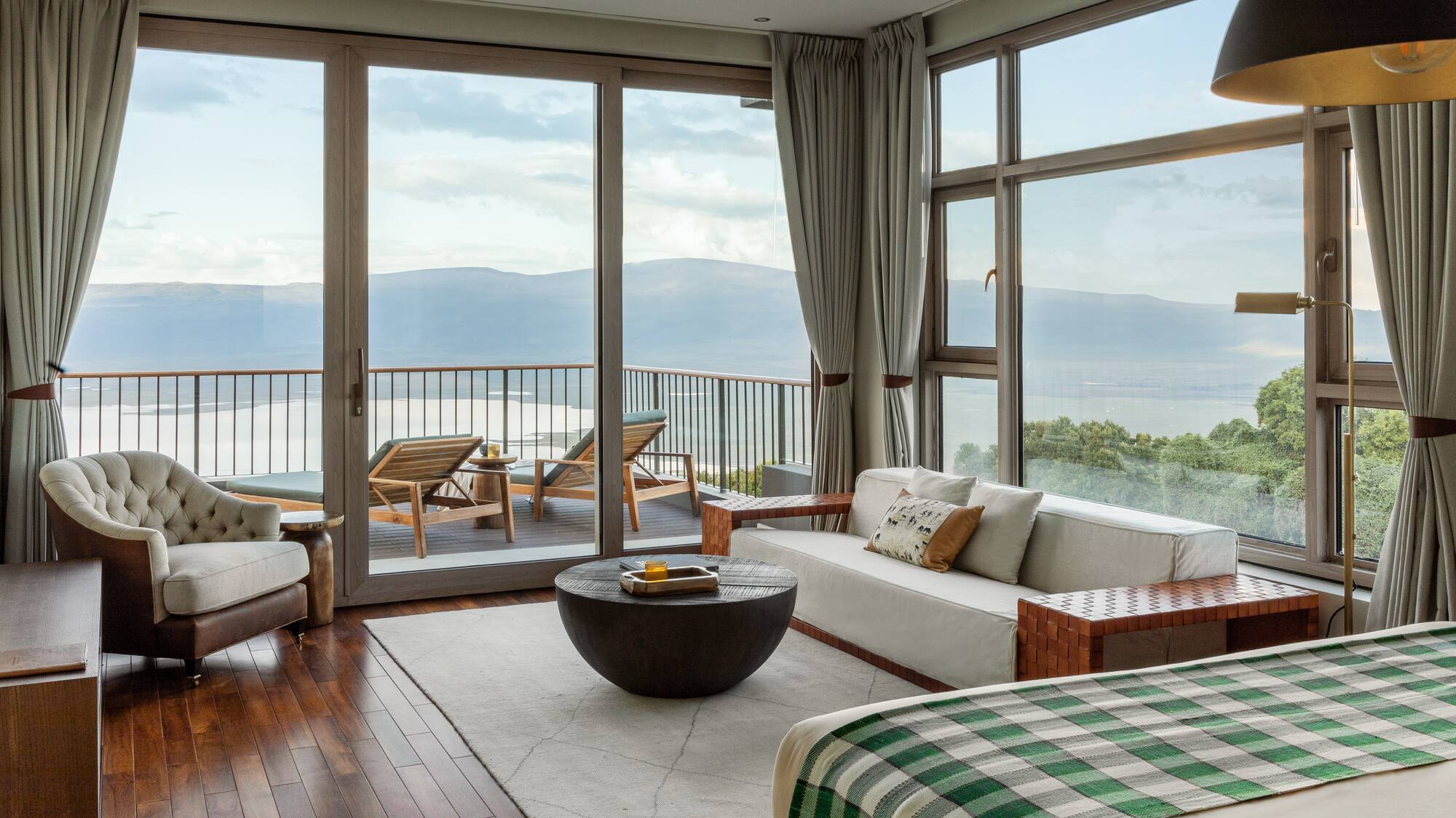 a room with a view of the ocean and a couch and a table
