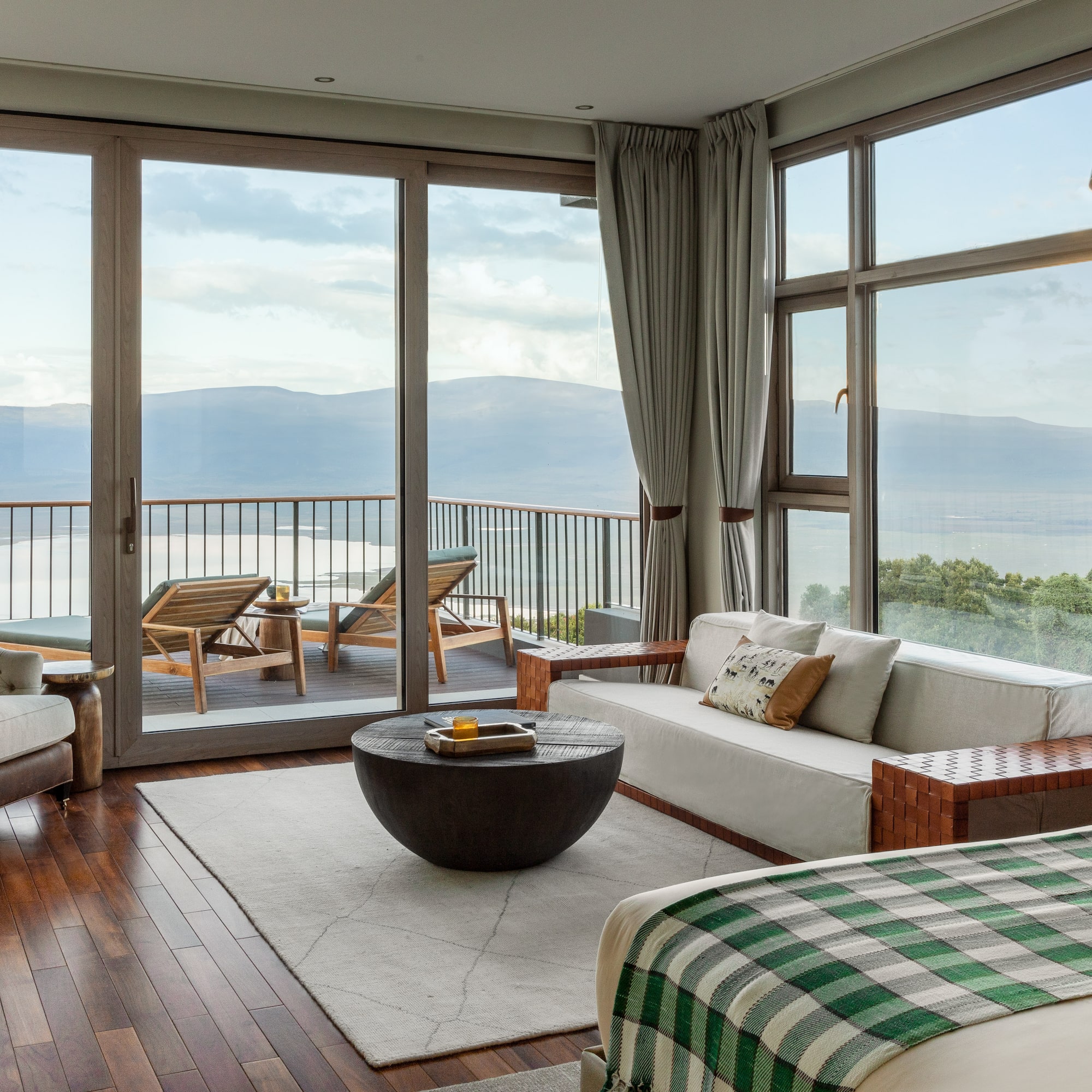 a room with a view of the ocean and a couch and a table