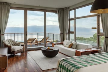 a room with a view of the ocean and a couch and a table