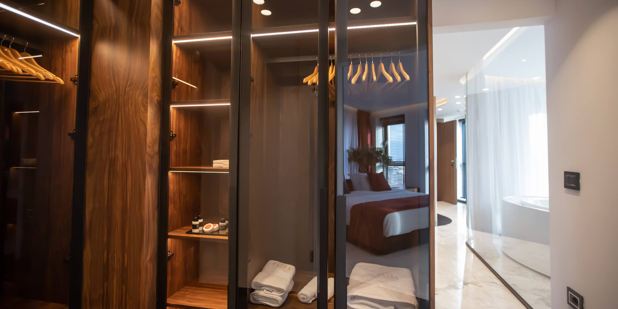 a closet with glass doors and shelves