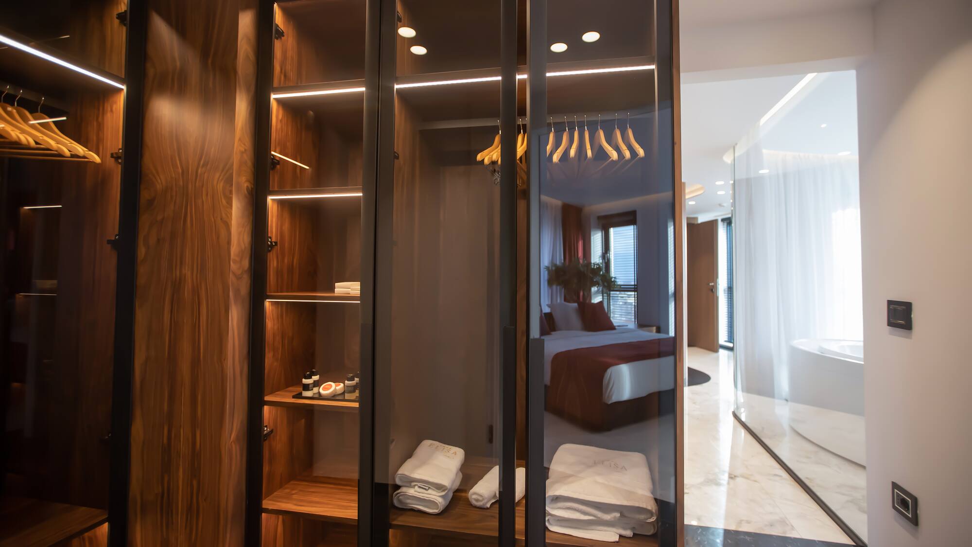a closet with glass doors and shelves