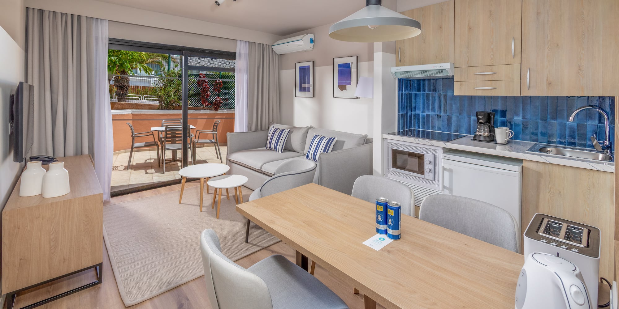 Modern apartment with open-plan living room, kitchen, dining area, and balcony.