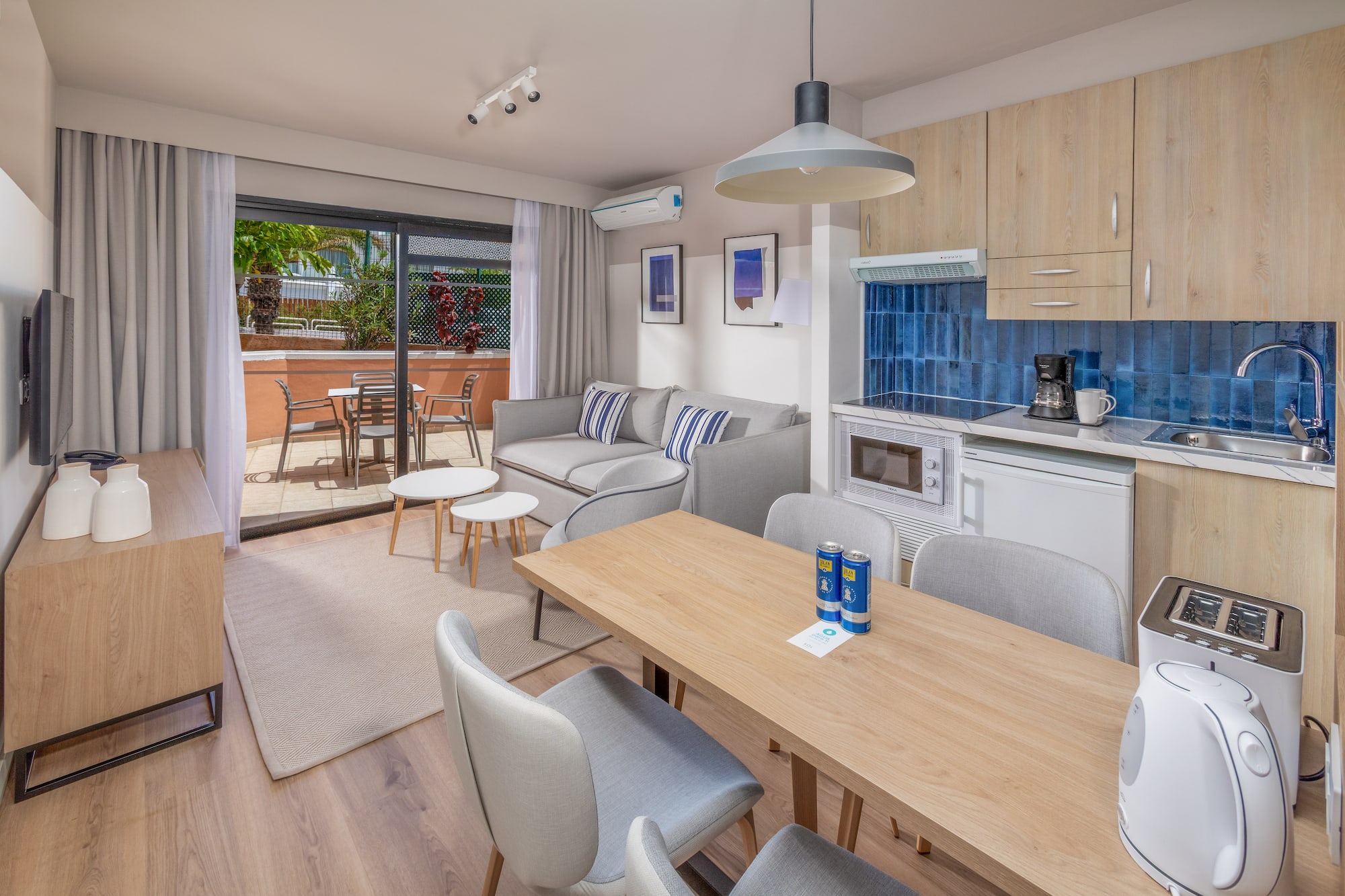 Modern apartment with open-plan living room, kitchen, dining area, and balcony.