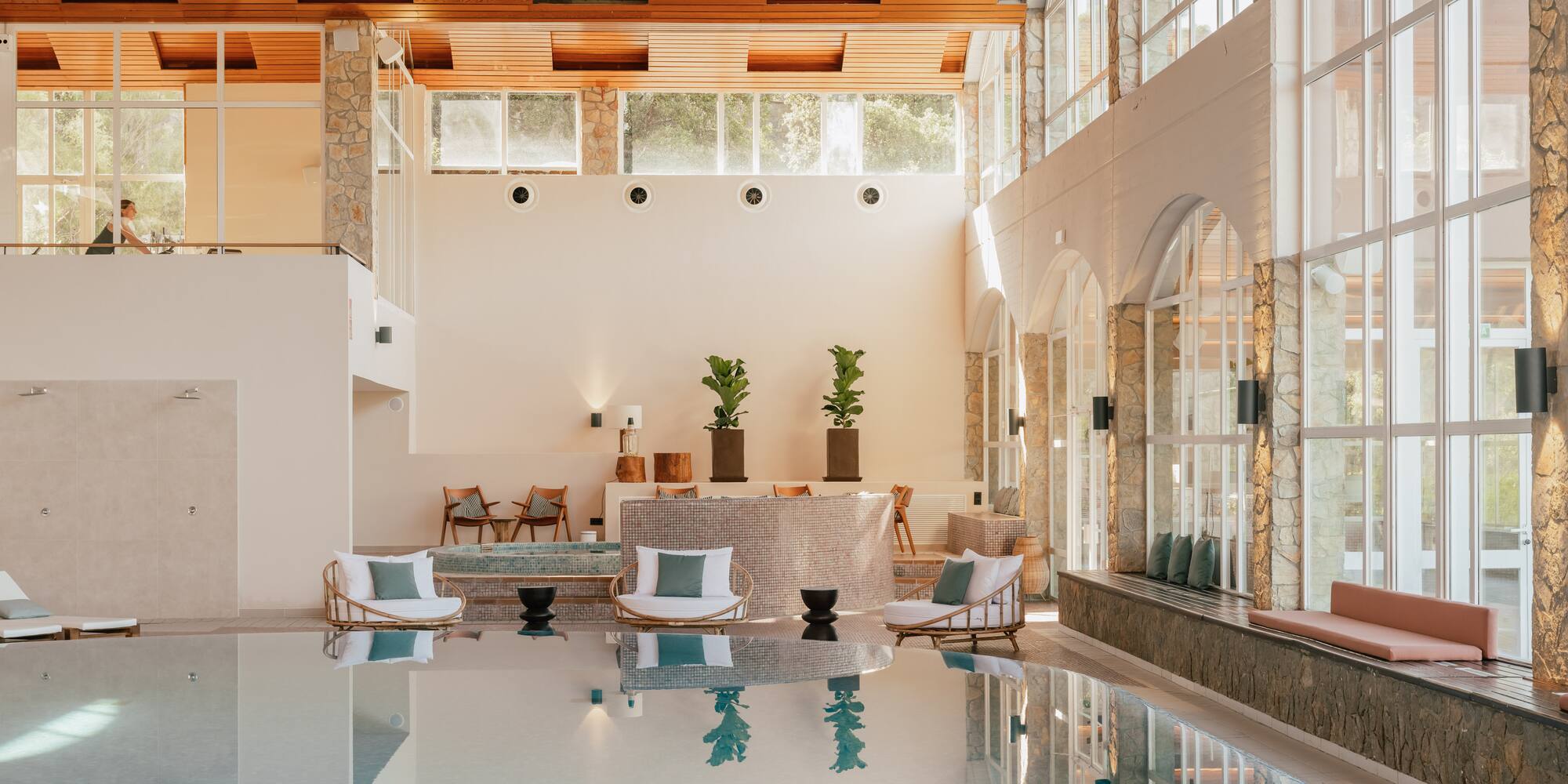 a indoor pool with a large stone wall and a stone ceiling