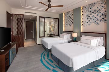 a room with two beds and a fan