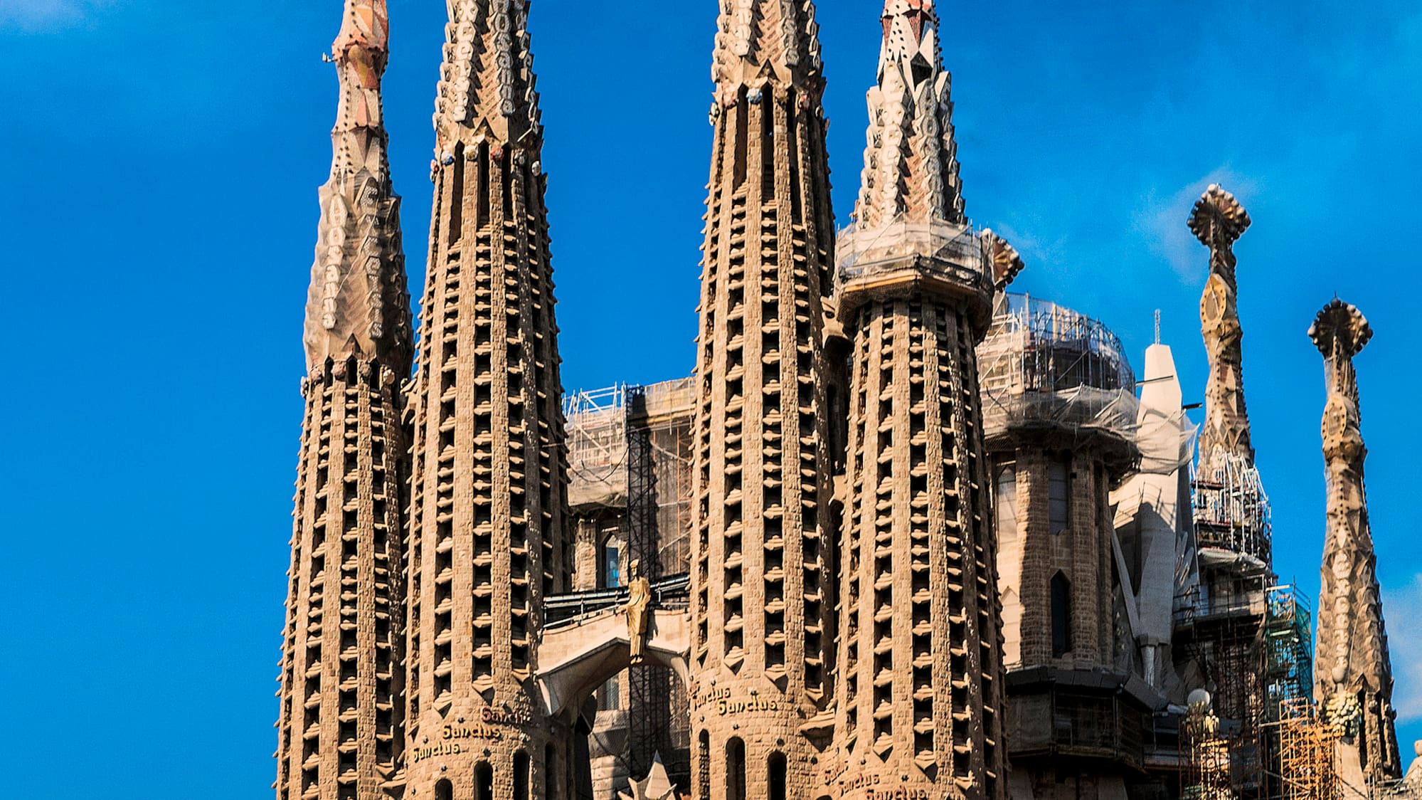 a large building with many spires with Sagrada Família in the background