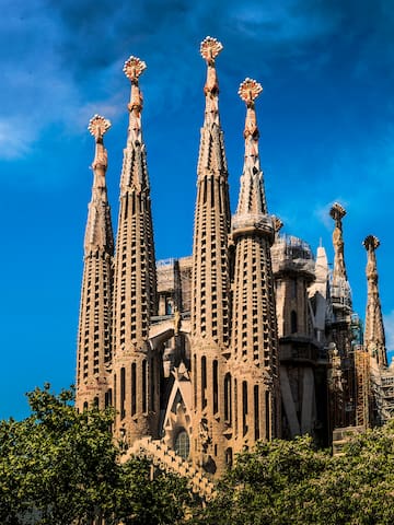 a large building with many spires with Sagrada Família in the background