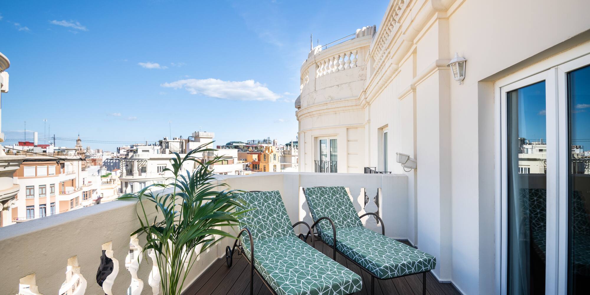 chairs on a balcony with a plant