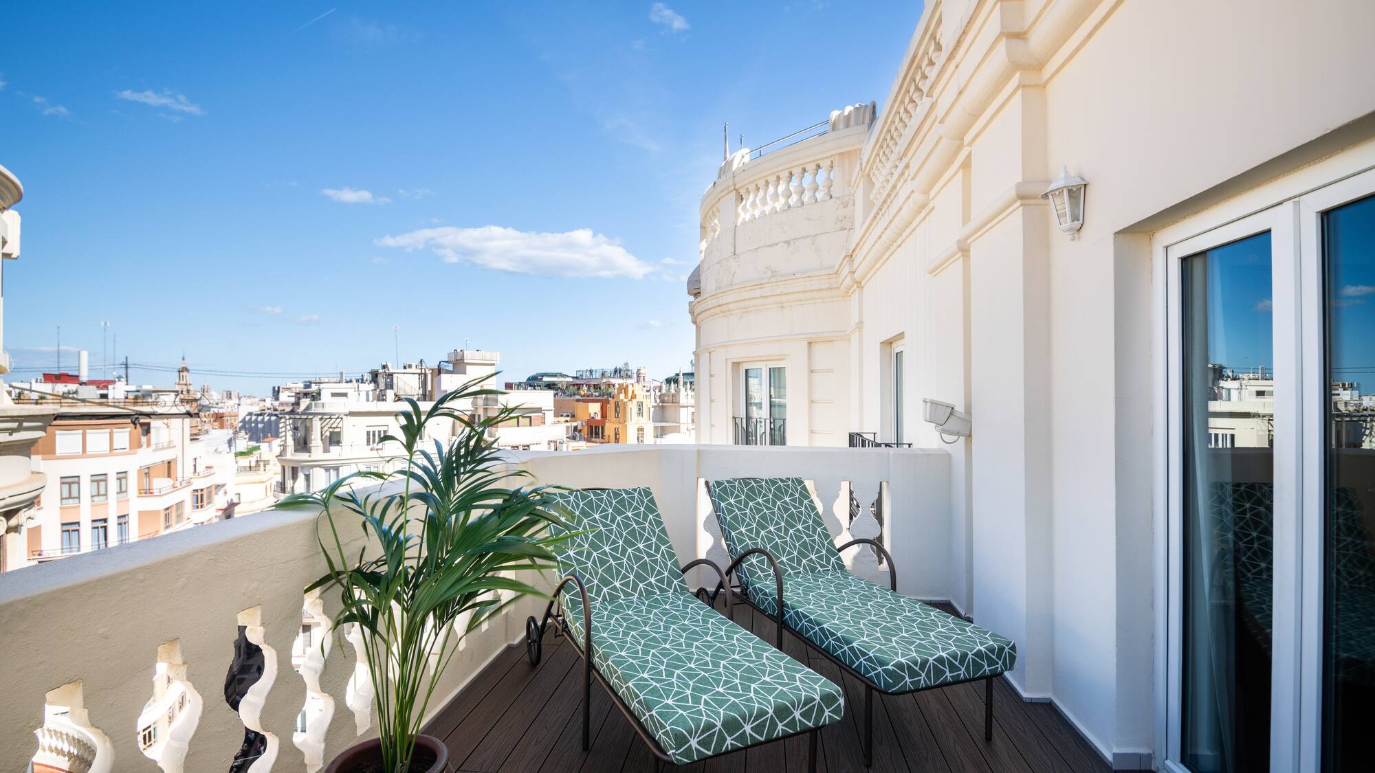 chairs on a balcony with a plant