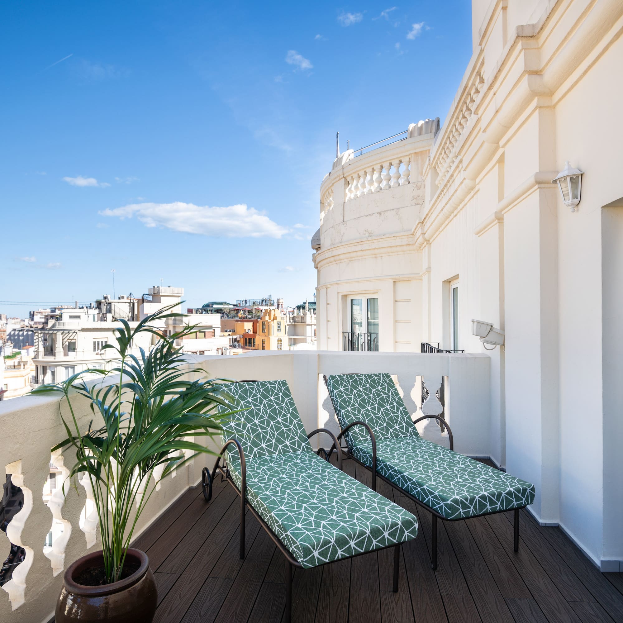 chairs on a balcony with a plant