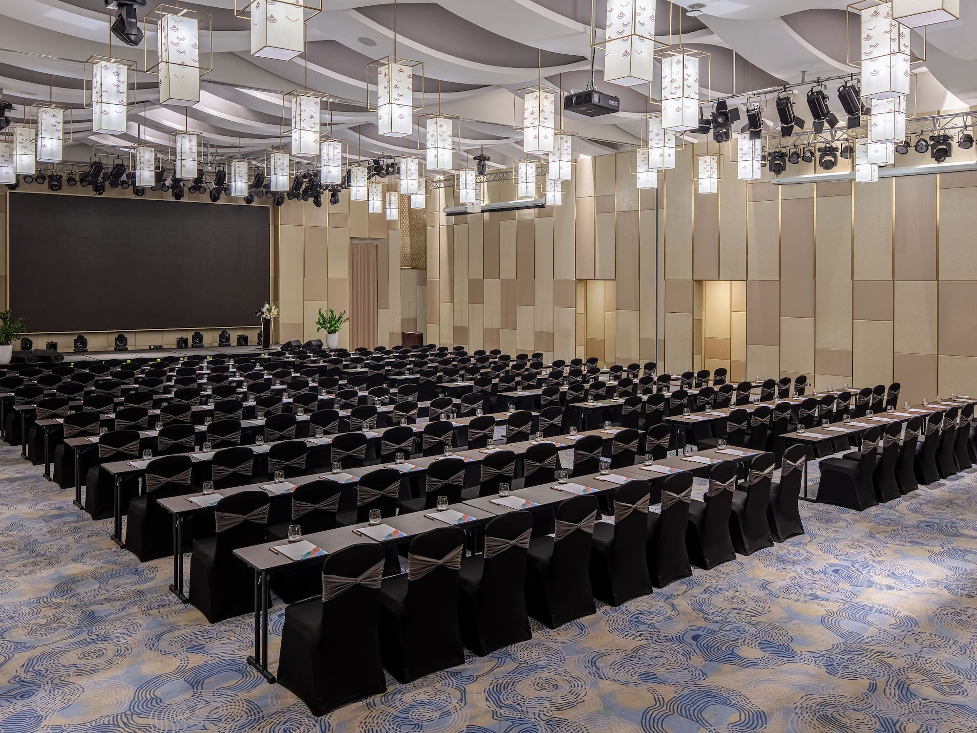 a large room with black chairs and a screen