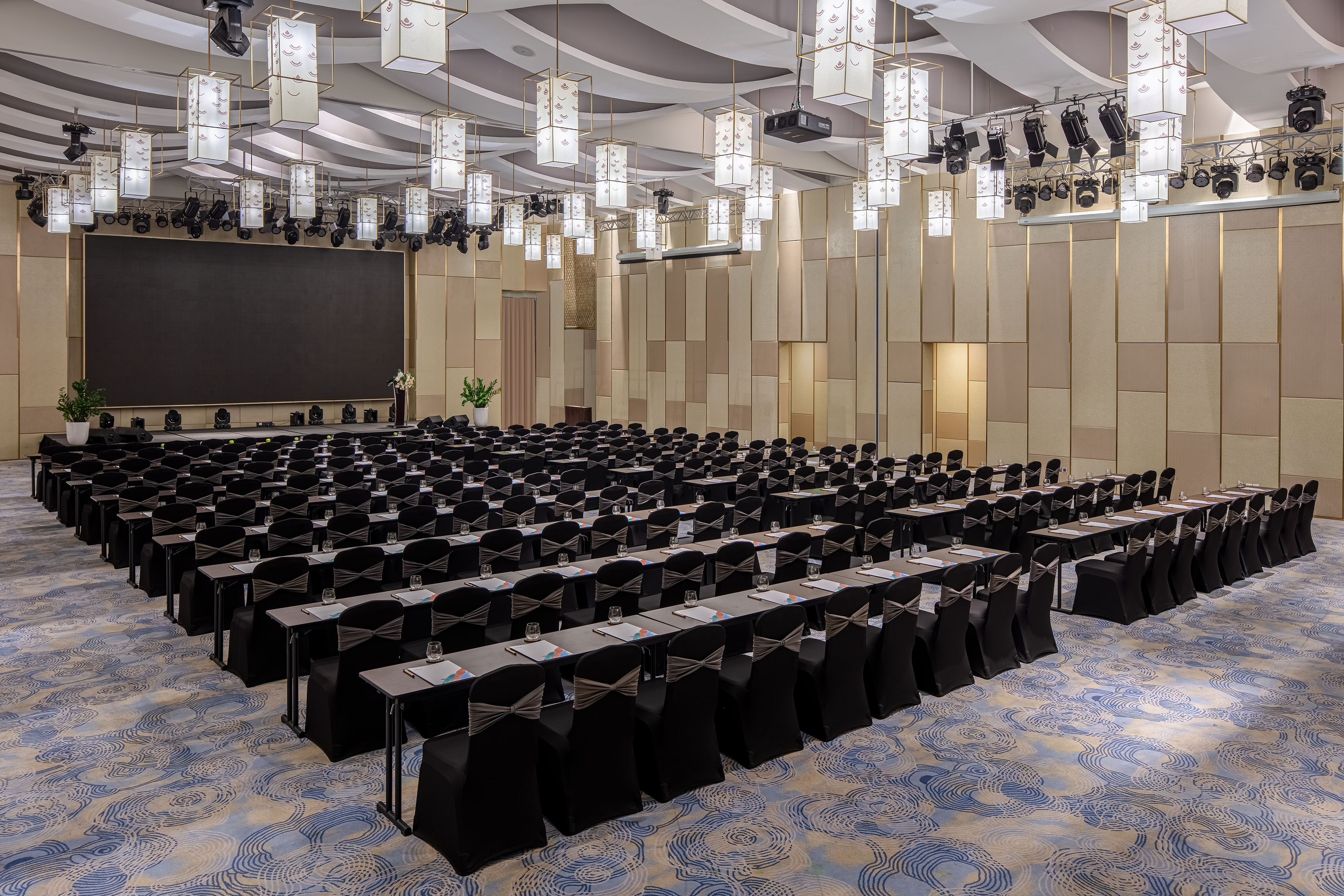 a large room with black chairs and a screen