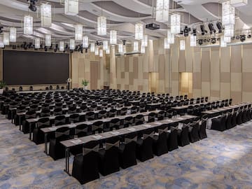 a large room with black chairs and a screen