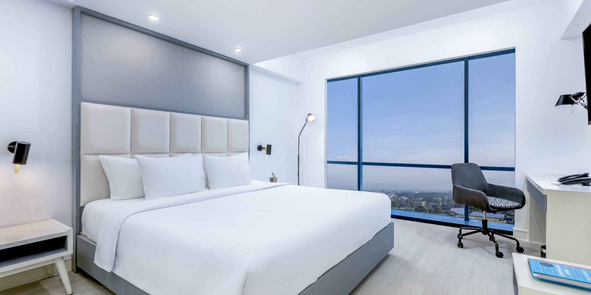 a bedroom with a large window and a large bed