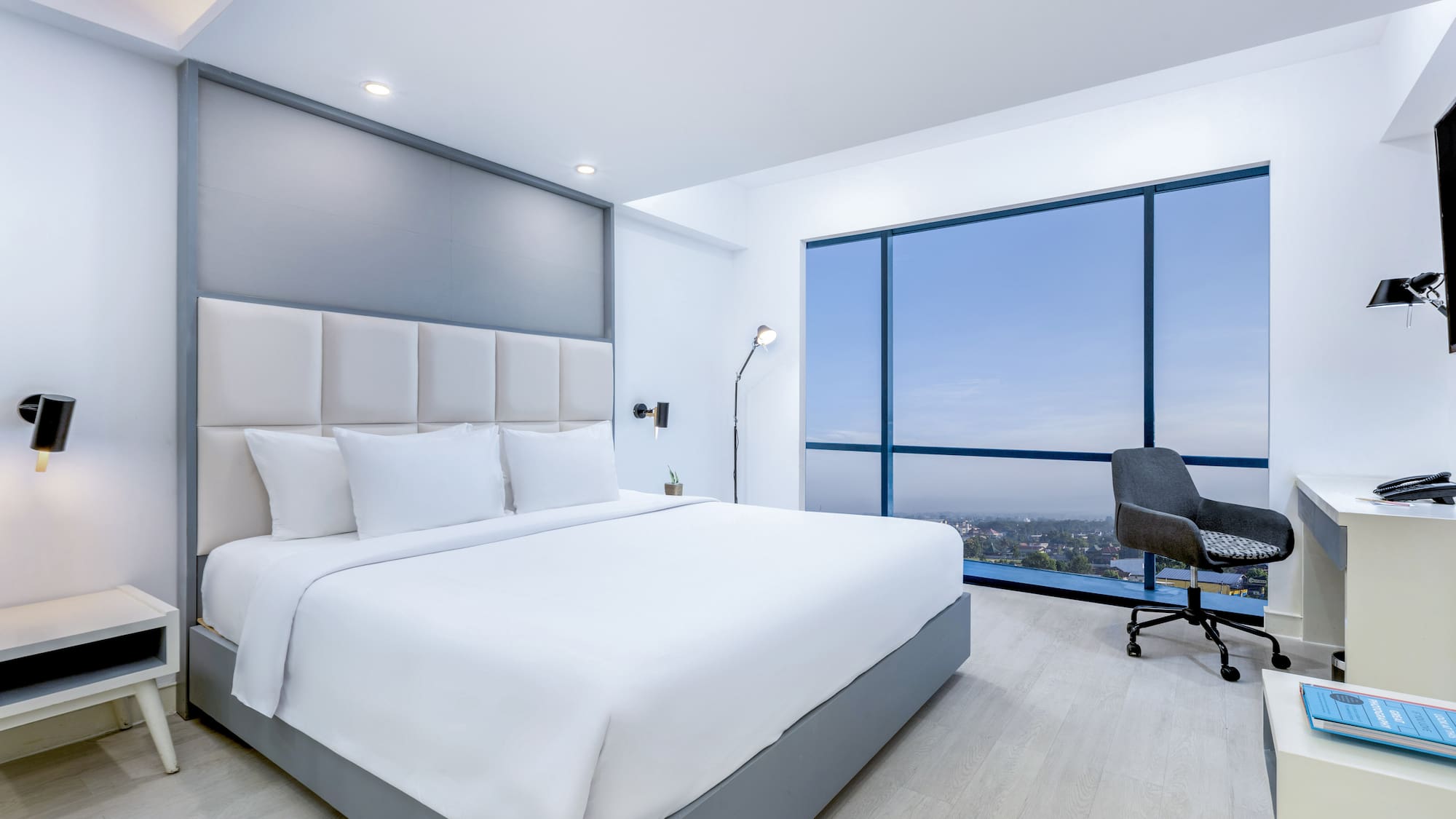 a bedroom with a large window and a large bed