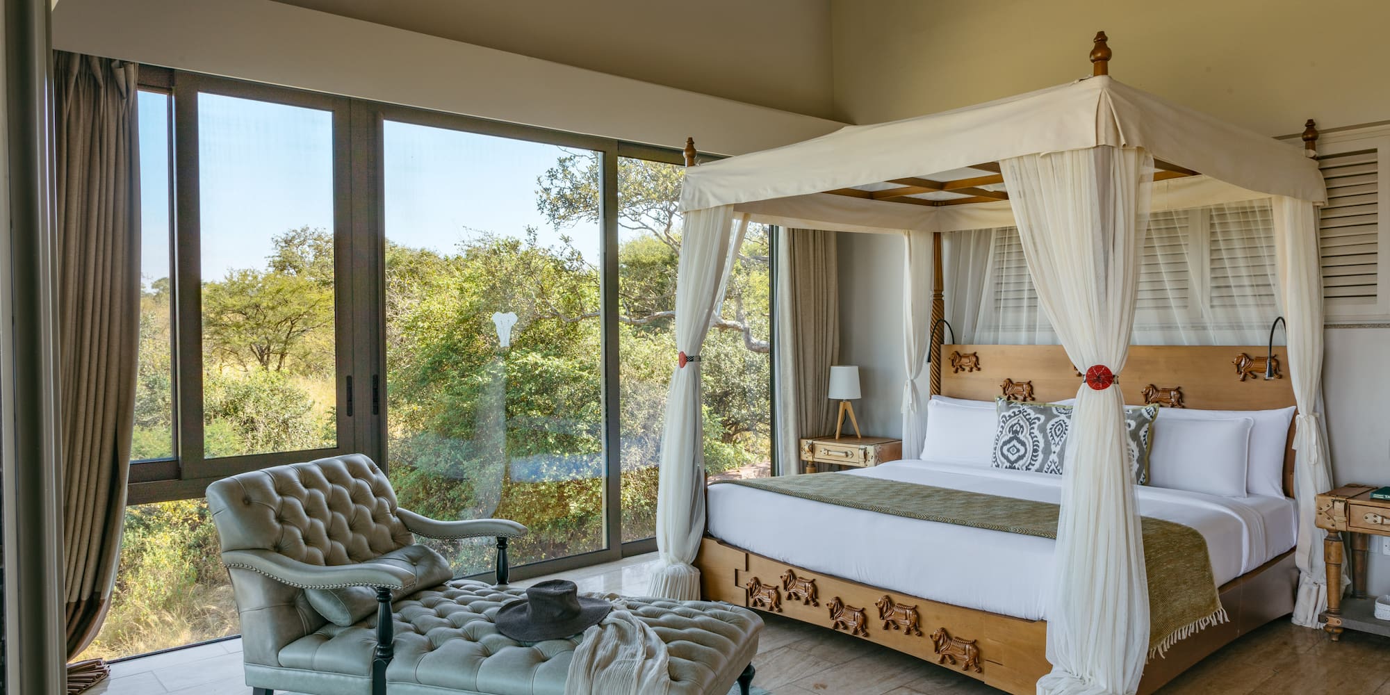 a bedroom with a canopy bed and a chaise longue