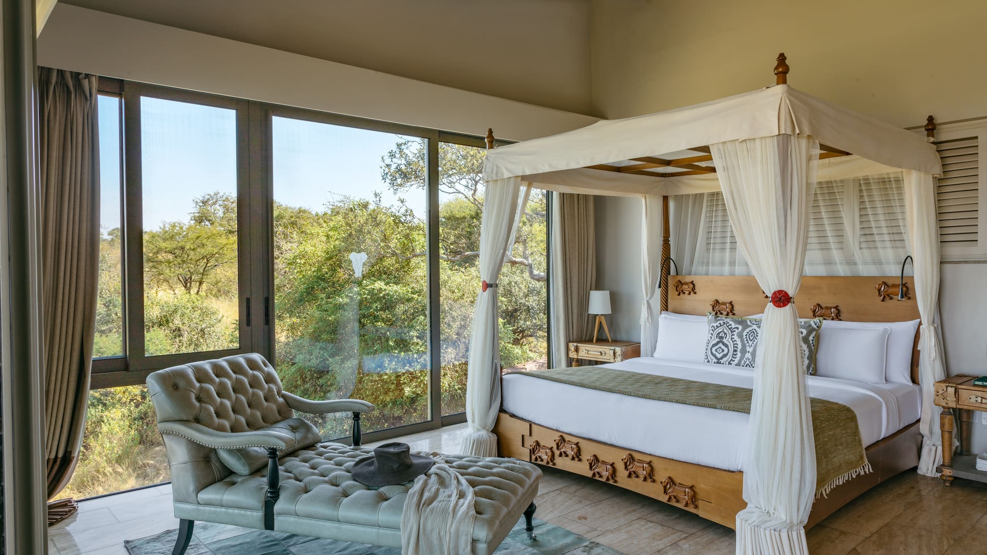 a bedroom with a canopy bed and a chaise longue