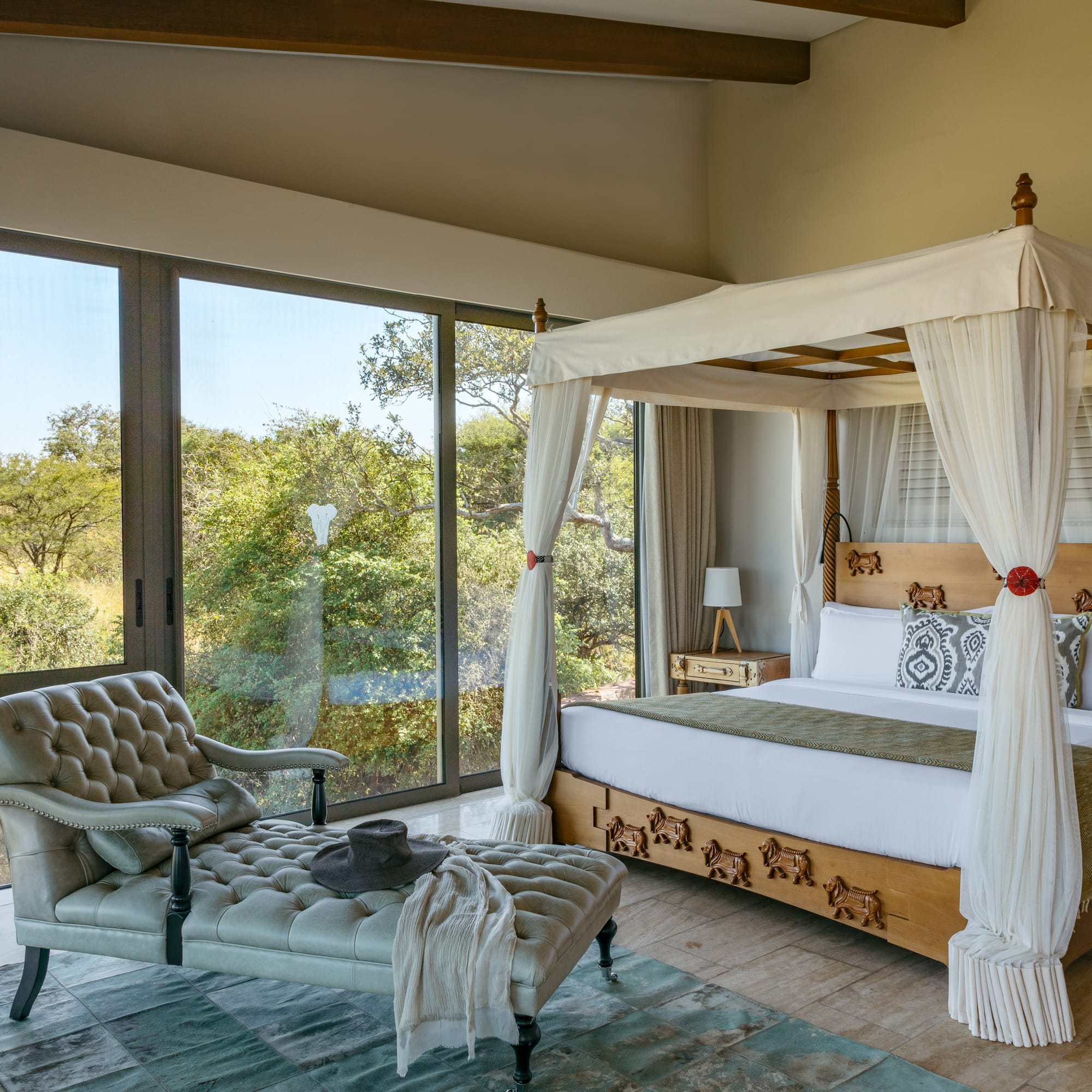 a bedroom with a canopy bed and a chaise longue