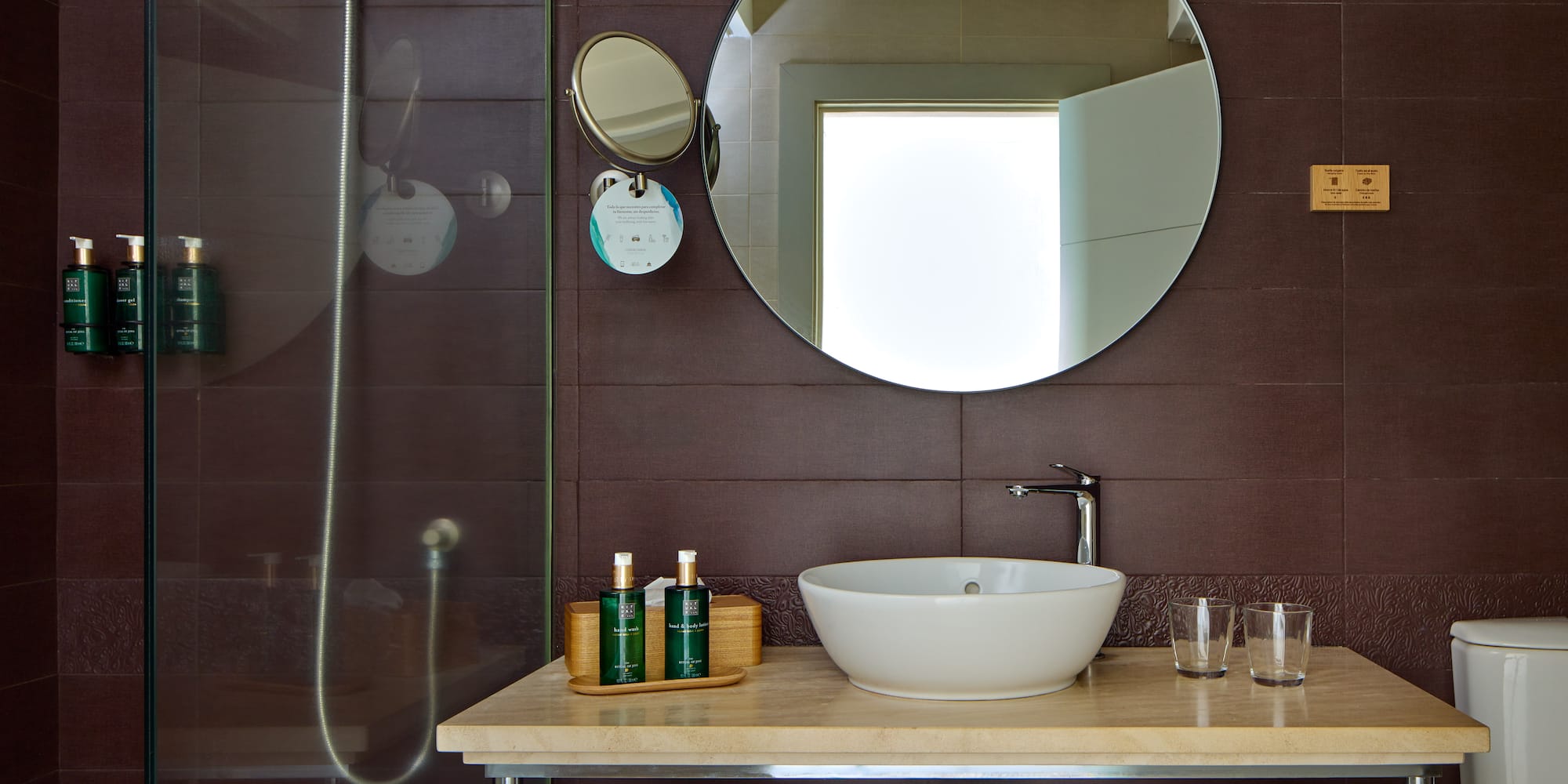a bathroom with a round mirror and a sink