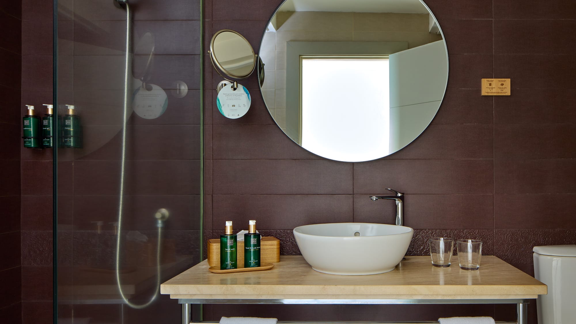a bathroom with a round mirror and a sink