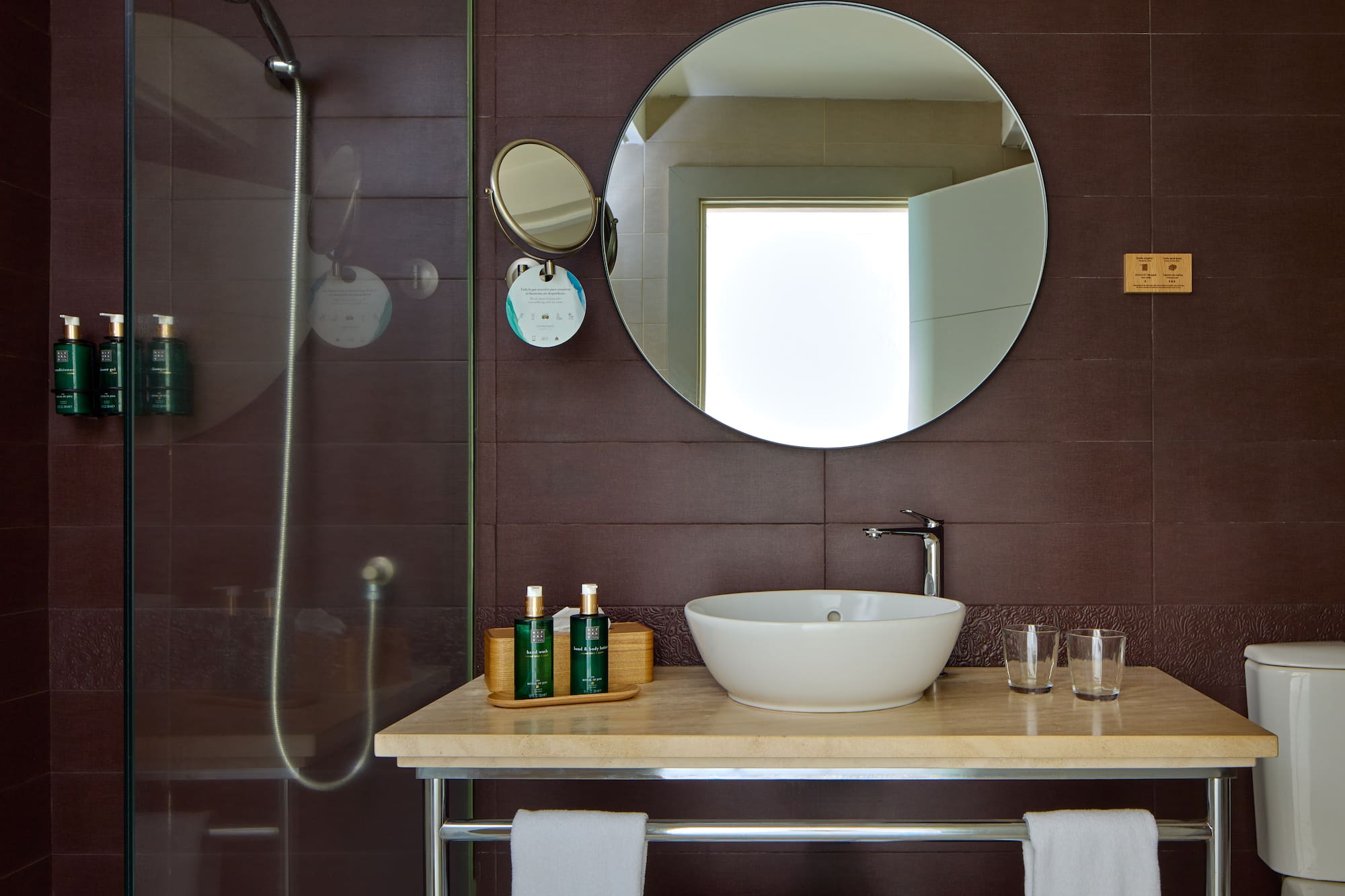 a bathroom with a round mirror and a sink
